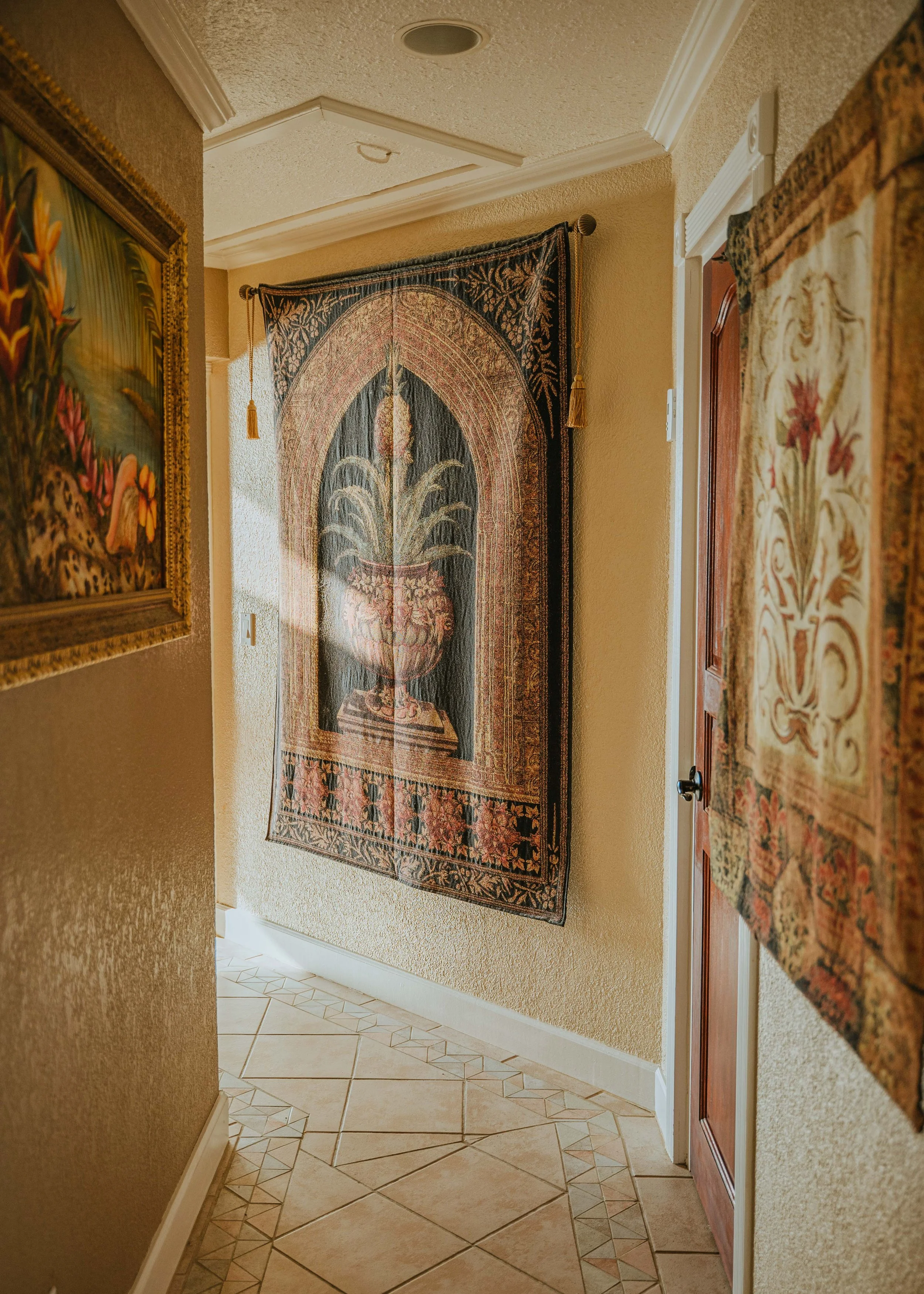 Hallway with tropical painting and tapestries on the walls