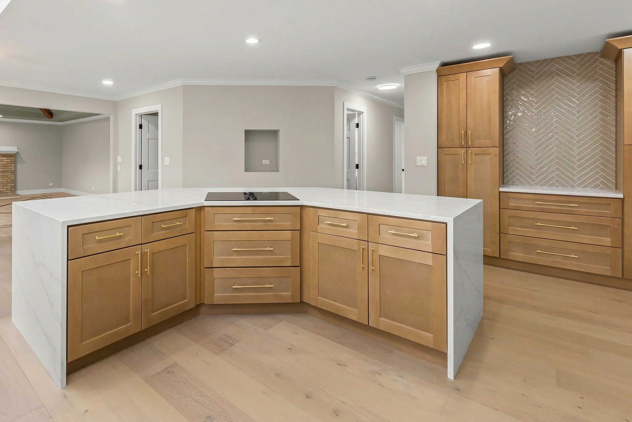Warm Honey Wheat cabinetry paired with a waterfall island creates a kitchen that&rsquo;s both functional and beautiful. The herringbone backsplash and brass hardware add just the right amount of detail to make the space stand out.

Designed for every