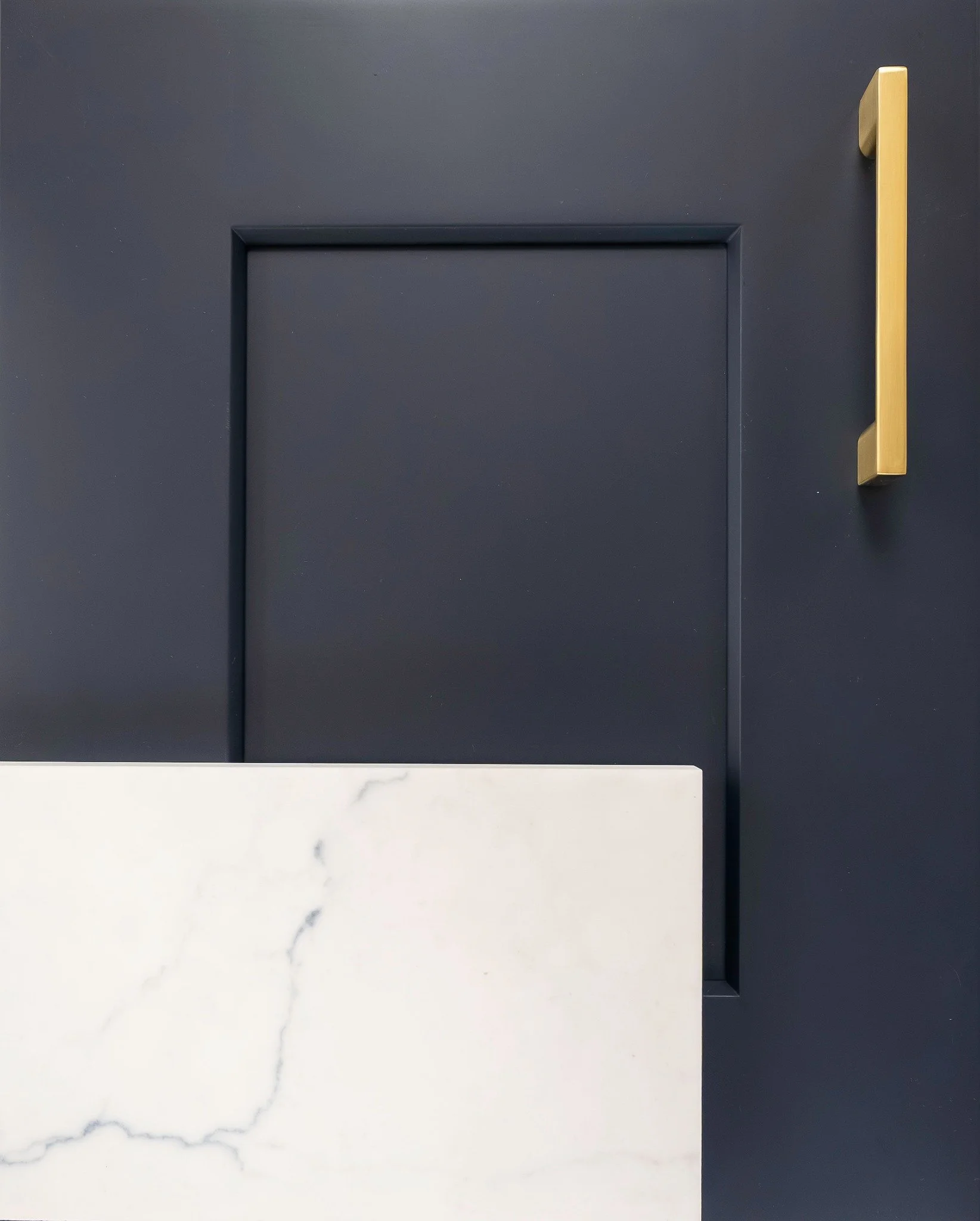 Midnight Blue shaker cabinetry is paired with a Calacatta Miraggio Cielo honed countertop and brushed gold pulls, a rich, sophisticated kitchen vignette where cool marble veining meets deep navy cabinetry, elevated by warm gold hardware for a timeles