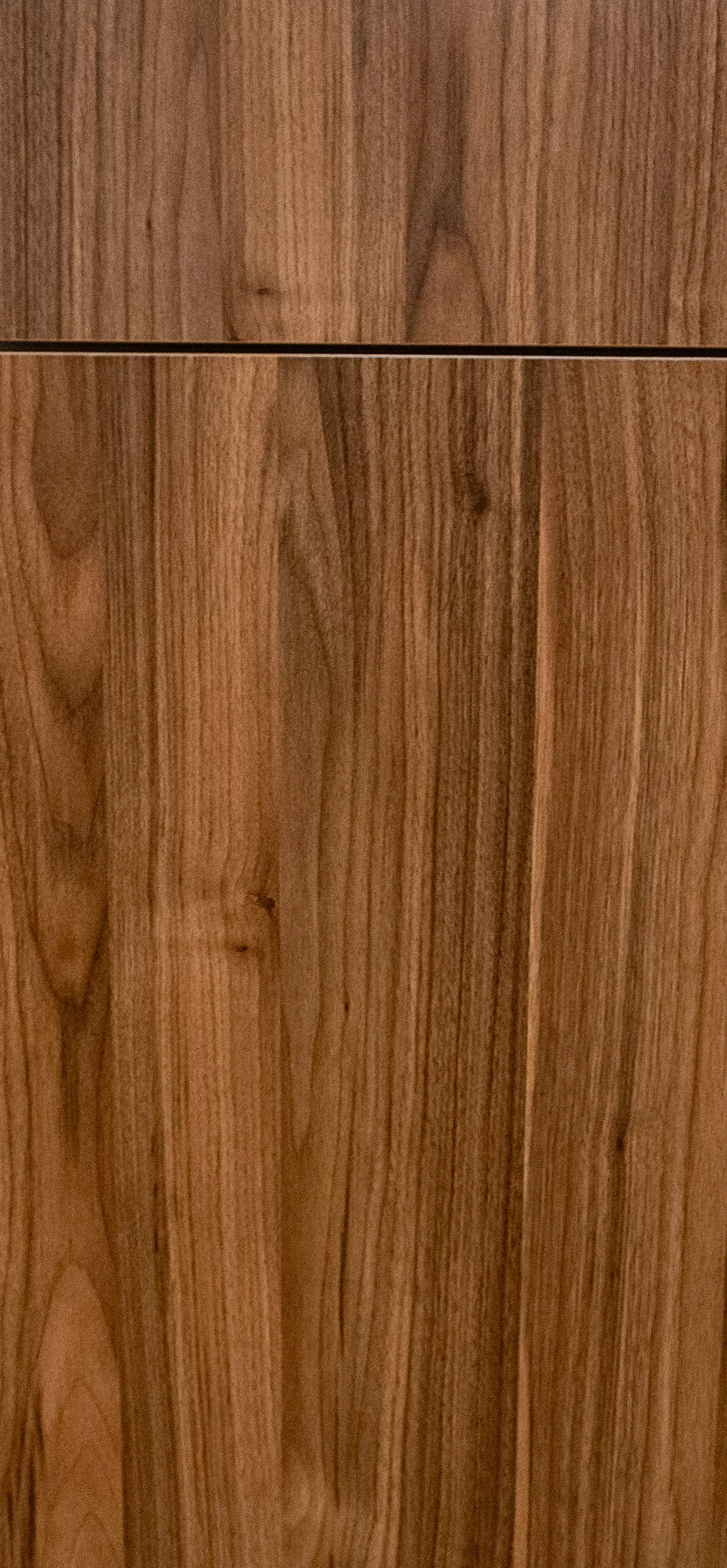 Close-up of wooden cabinet doors with natural wood grain pattern and vertical panels. Door face for frameless cabinet.