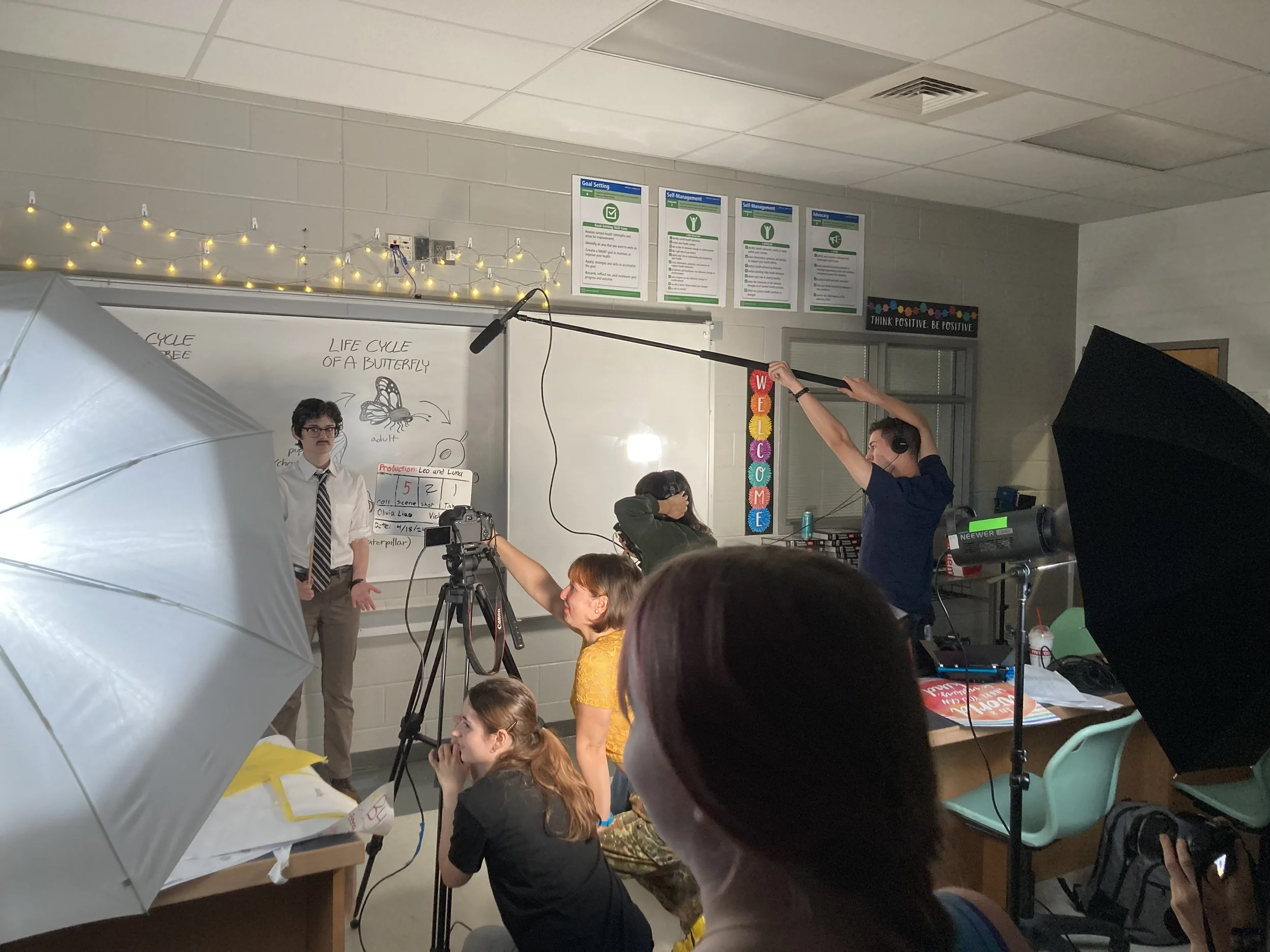 teenagers filming a scene in a classroom