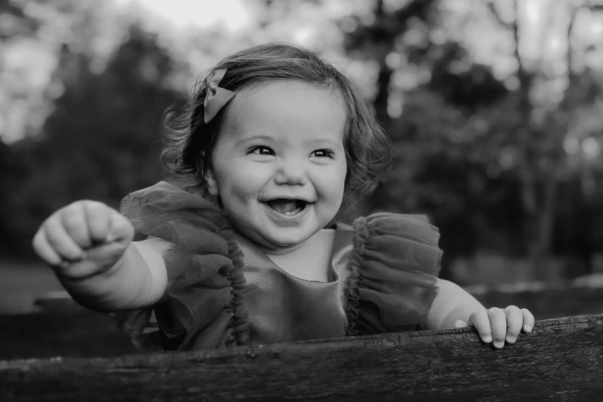 Toddler girl smiling so big dressed in red christmas dress 