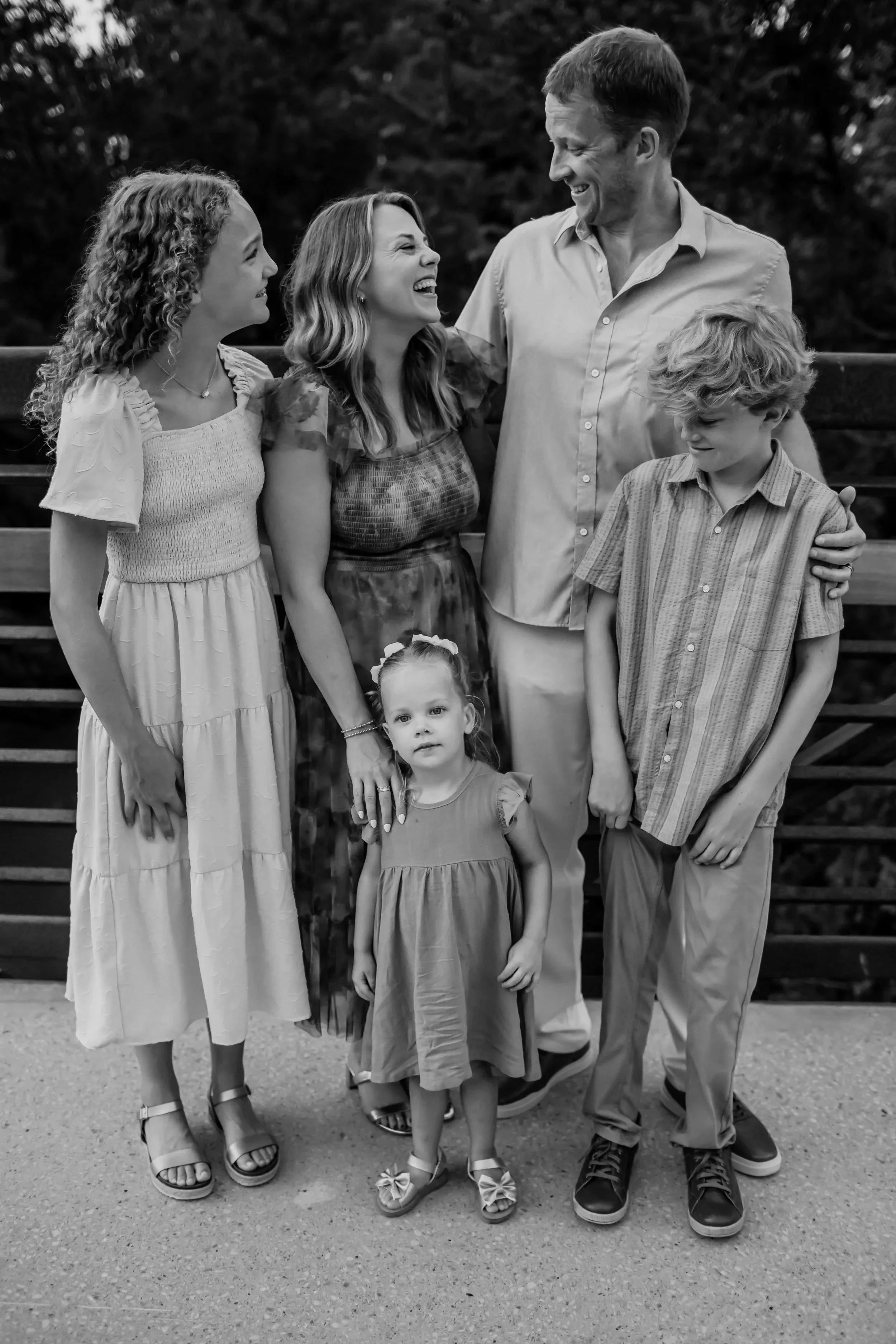 Mt Juliet family of 5 are laughing together on a bridge near Cedar Creek