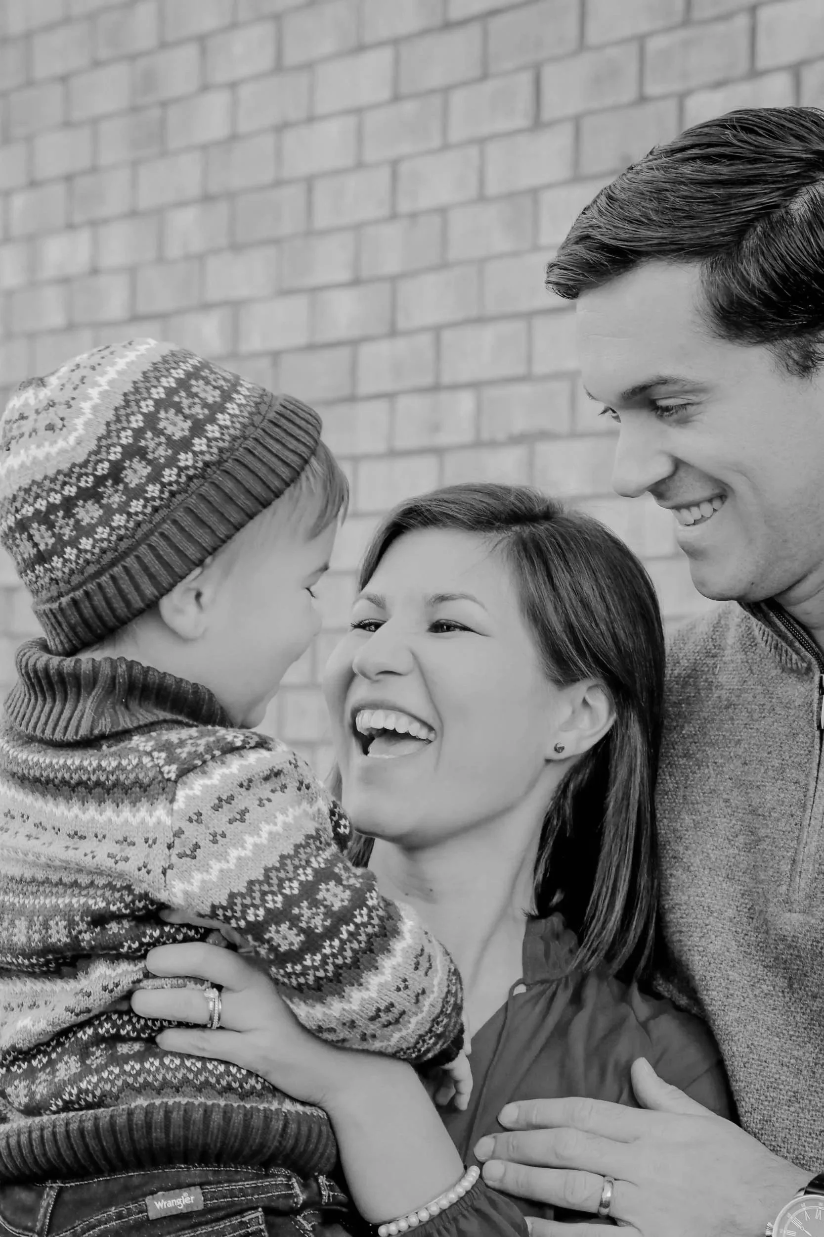 Family of three pose with their young boy in warm winter sweaters in Hermitage TN