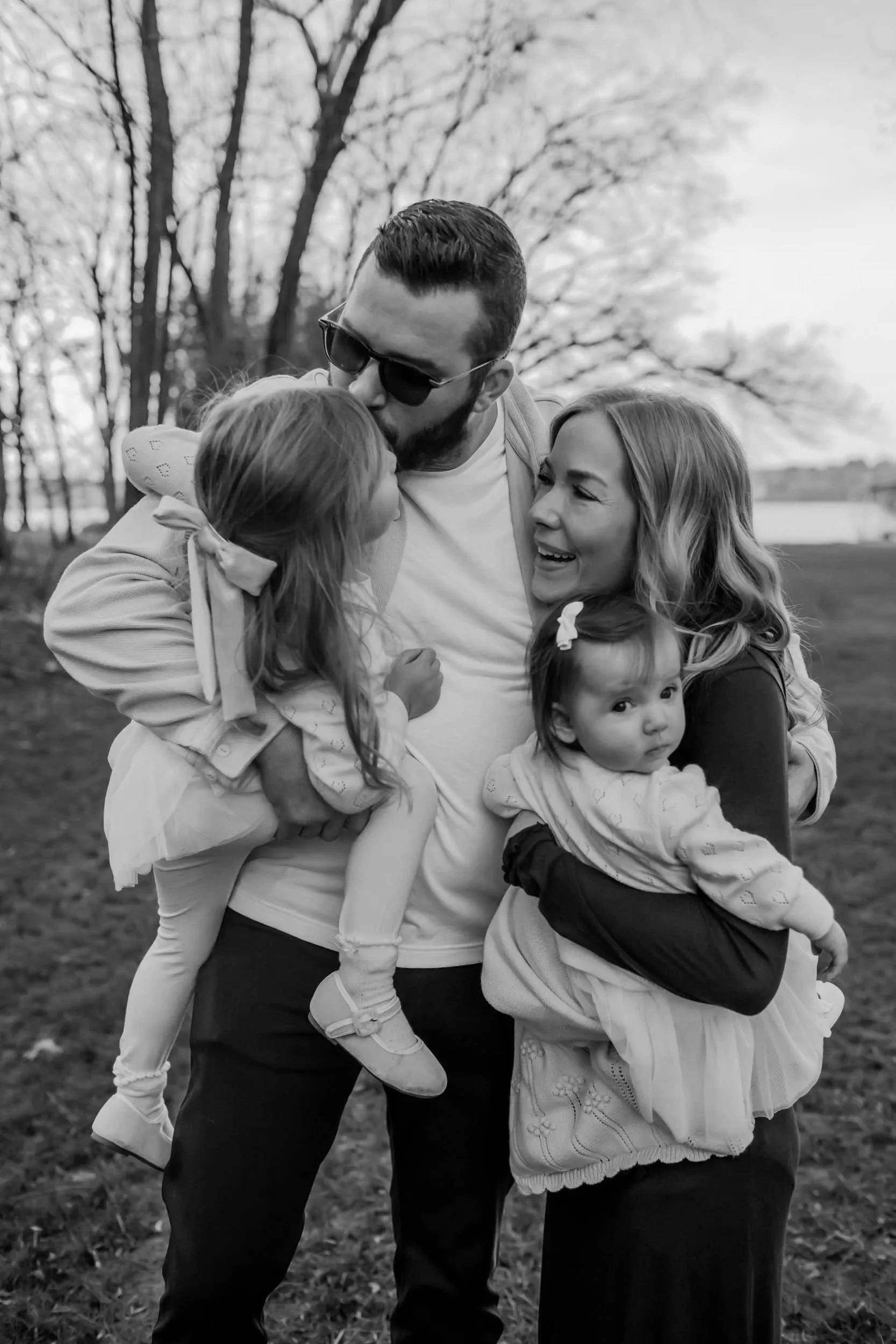 family embraces each other all smiling and nuzzling into each other on Old Hickory Lake in Tennessee