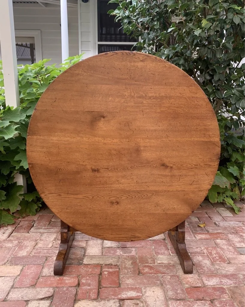 French oak tilt-top vendange table c.1930, oval top tilted vertical, planked surface with aged patina
