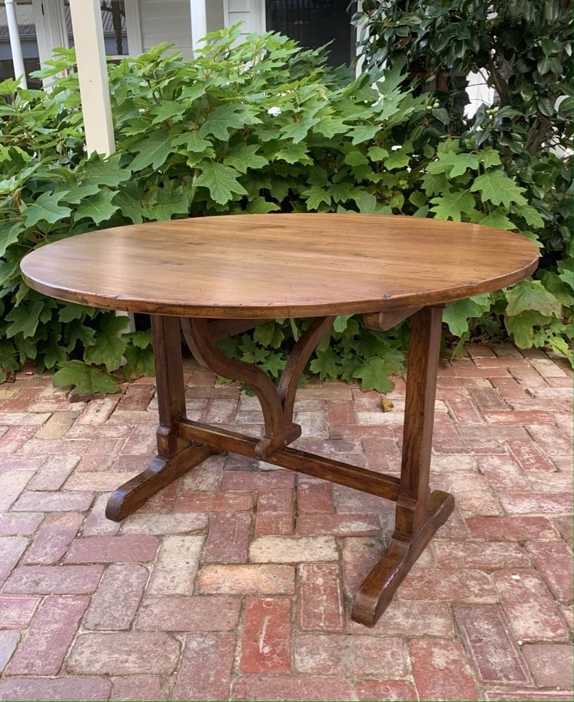 French oak vendange wine table c.1930 front view, oval top horizontal, shaped stretcher beneath