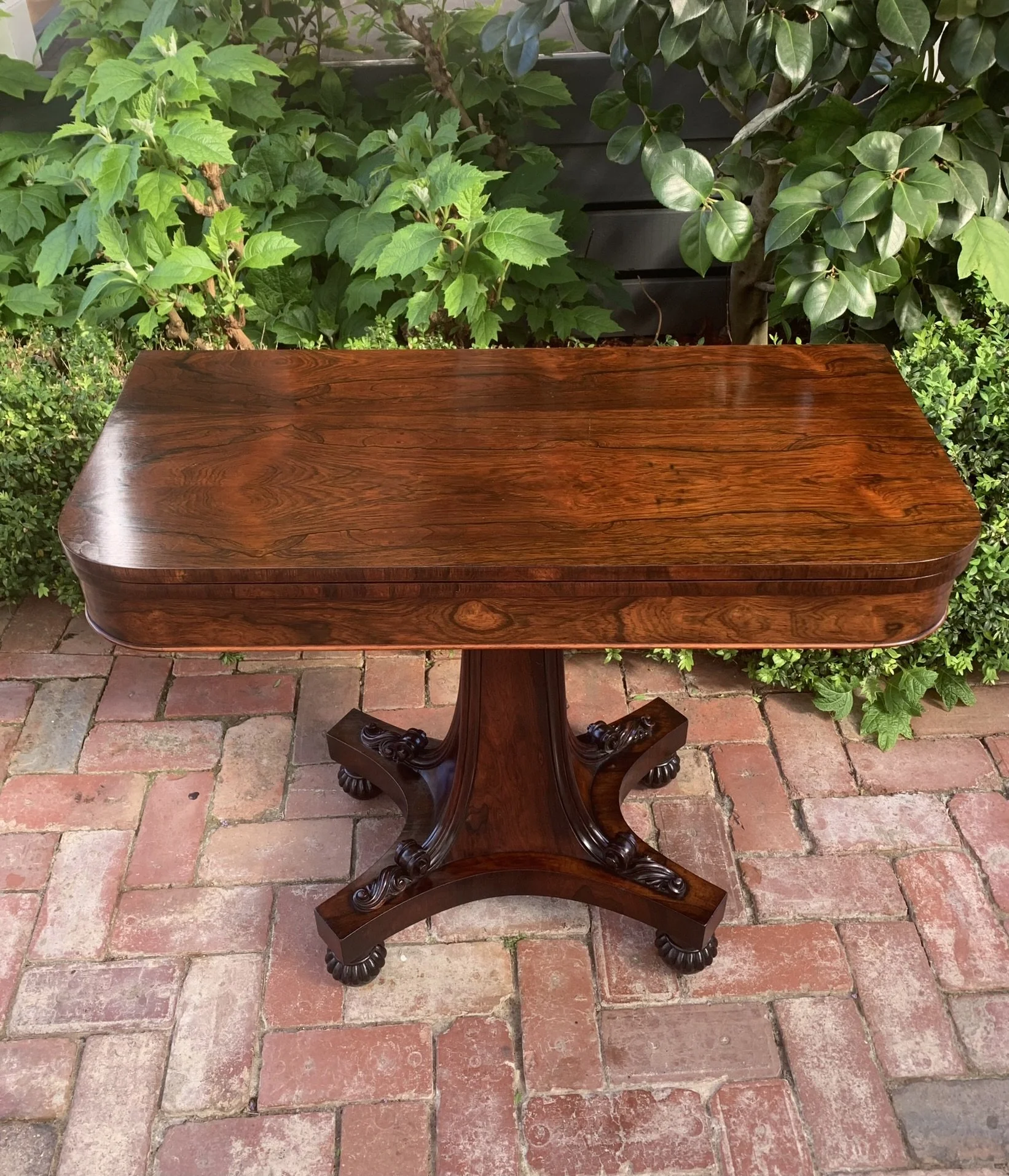 Antique rosewood card table, William IV period C.1830-1837, fold-over games table on carved quadripartite platform base
