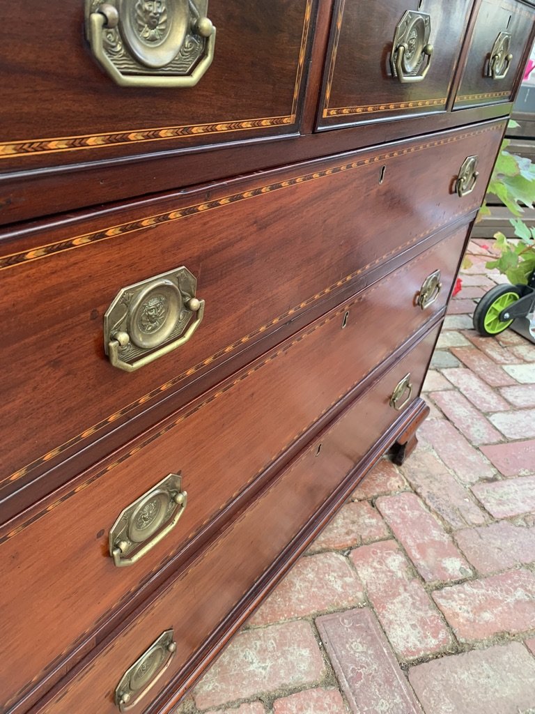 angled view of chevron inlaid drawer fronts and brass handles