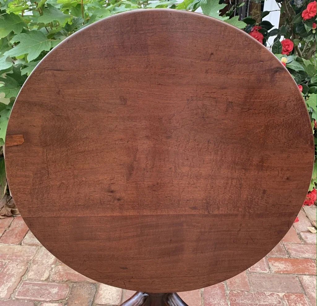 Antique mahogany circular tabletop showing single-plank timber and patina