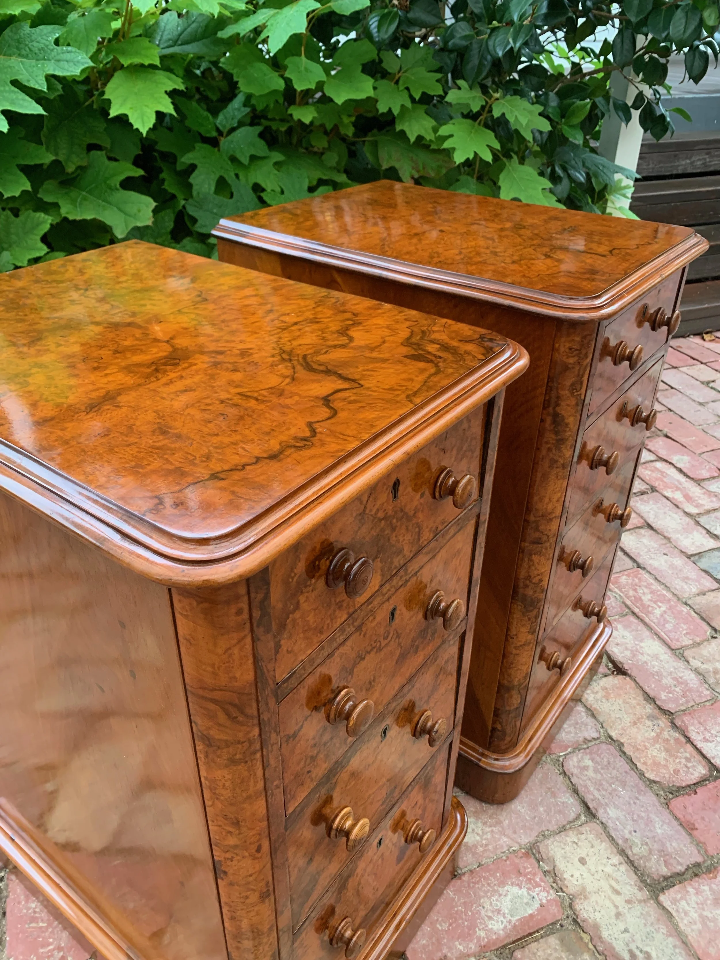 view of tops of pair of antique burr walnut bedside chests with graduating drawers and turned knobs circa 1870 