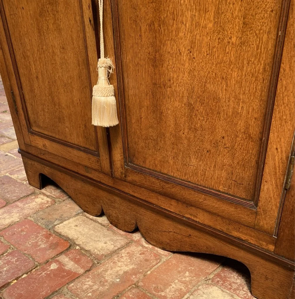 close up of lower section and moustache shaped bracket base of georgian oak corner cabinet