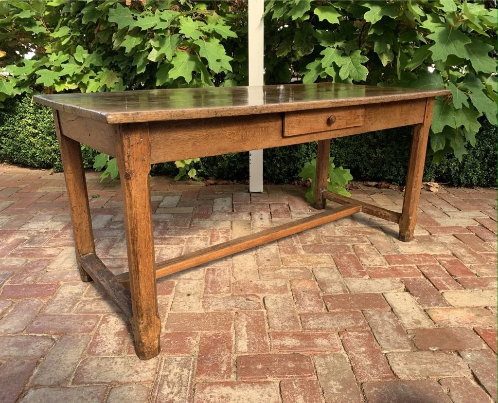 19th-century French provincial oak farm table — angled view showing H-stretcher base and tapered legs