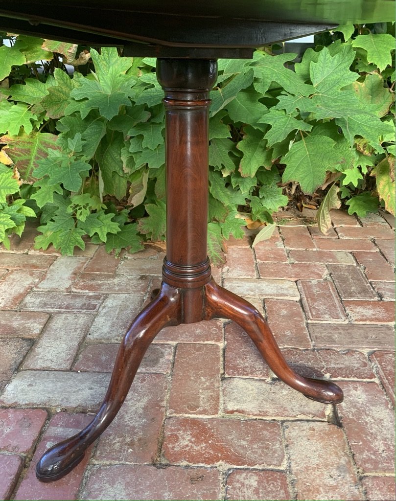 Detail of George III mahogany wine table base, showing reeded collar, plain turned cylindrical column, and three swept cabriole legs with pad feet, English circa 1770-1790