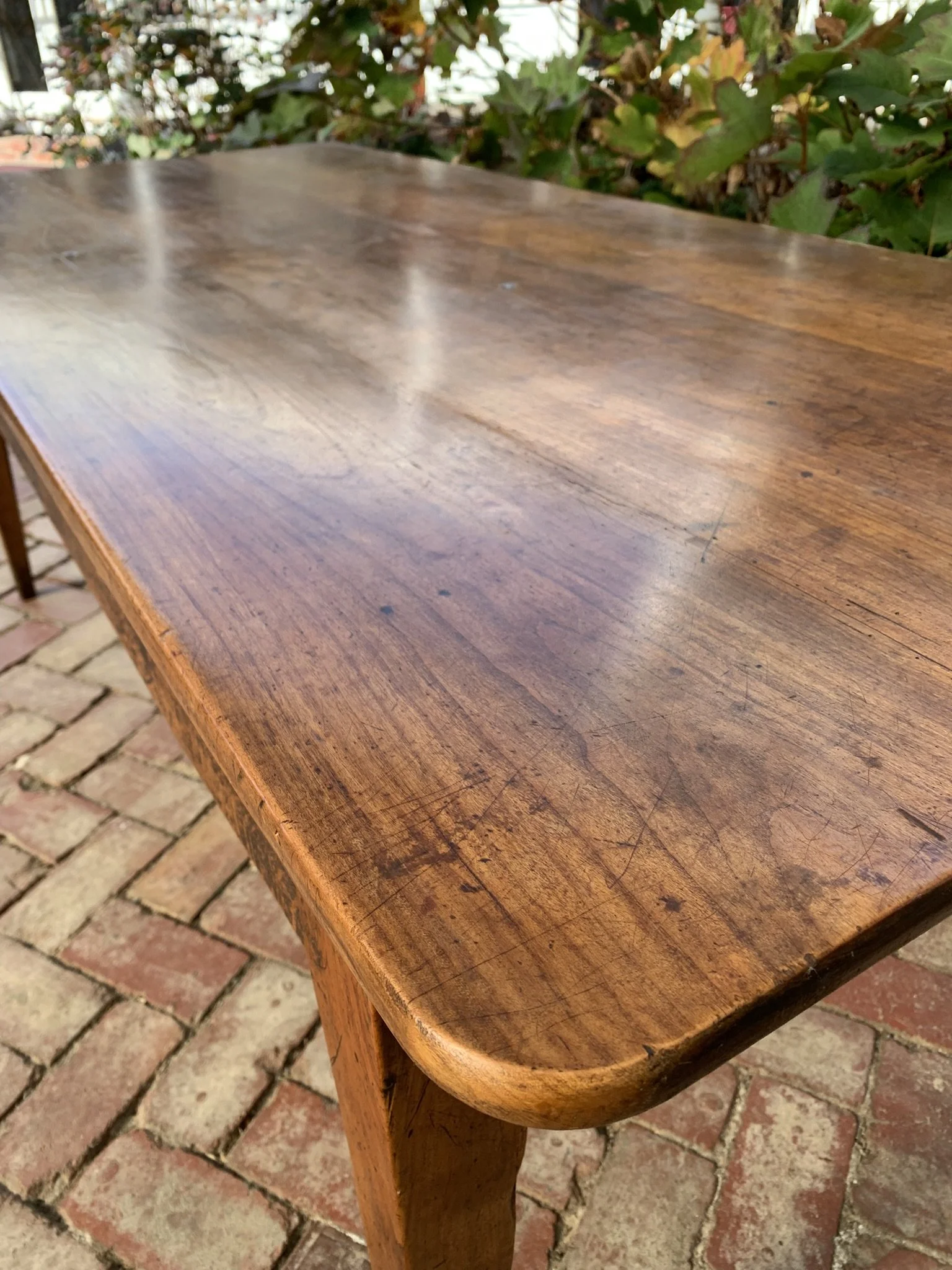 Detail of rounded corner and tapered oak leg on antique French cherry farmhouse table