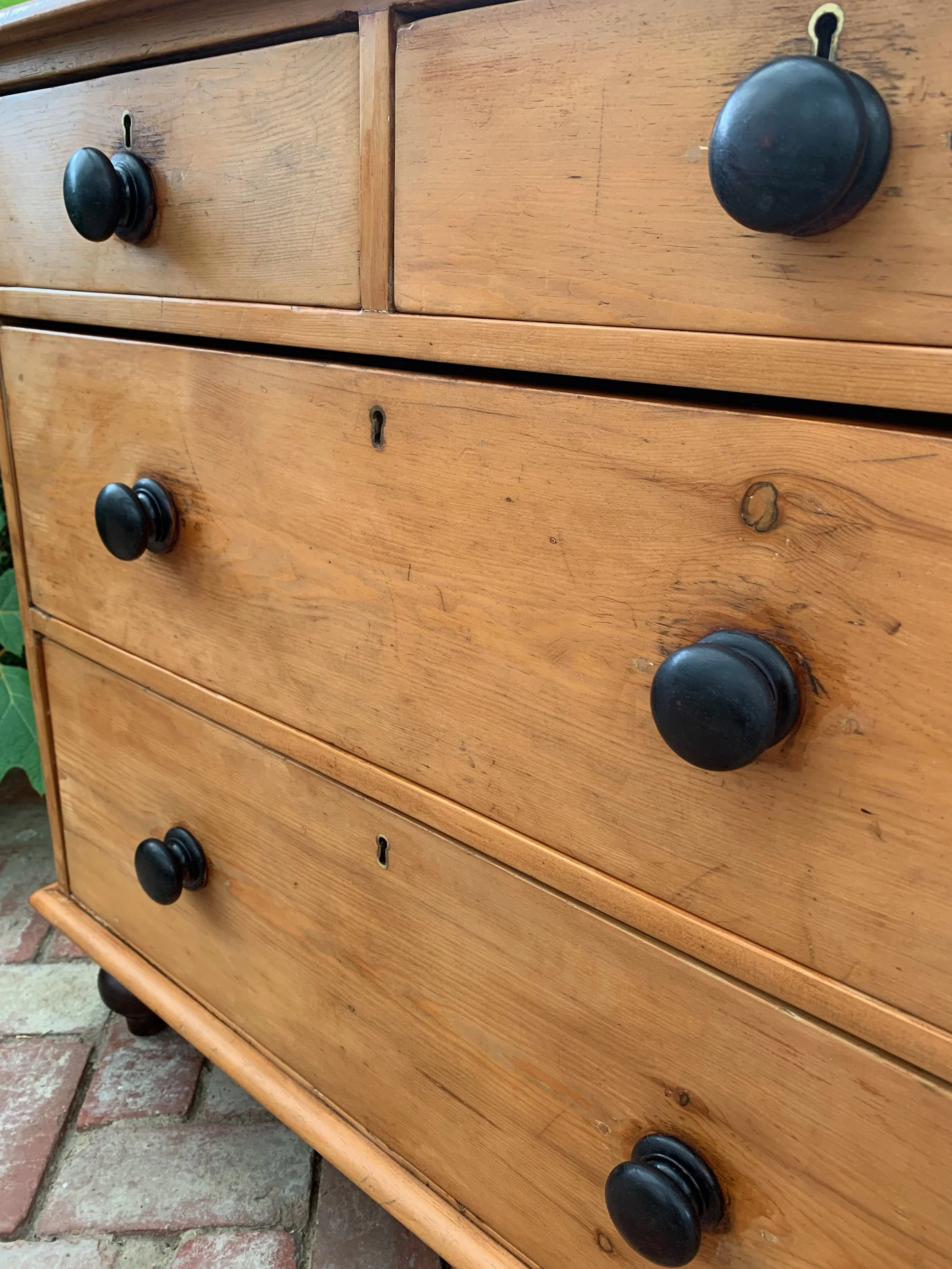 Near view of of drawer fronts of late victorian pine chest of drawers
