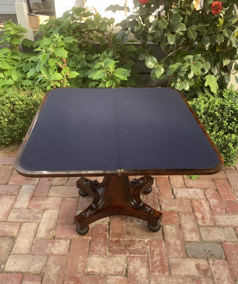 William IV rosewood card table C.1835, carved scroll foliage platform base, moulded pillar, lobed bun feet, pedestal table