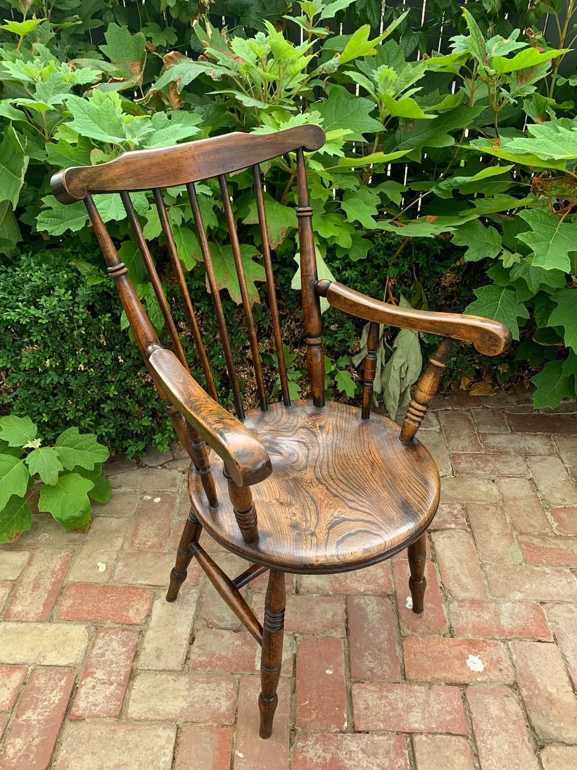 Antique penny seat Windsor armchair with stick back and turned legs, three-quarter view