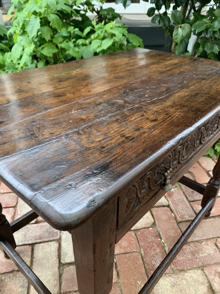 Antique oak side table corner detail showing rich patina, grain and carved frieze drawer with brass handle