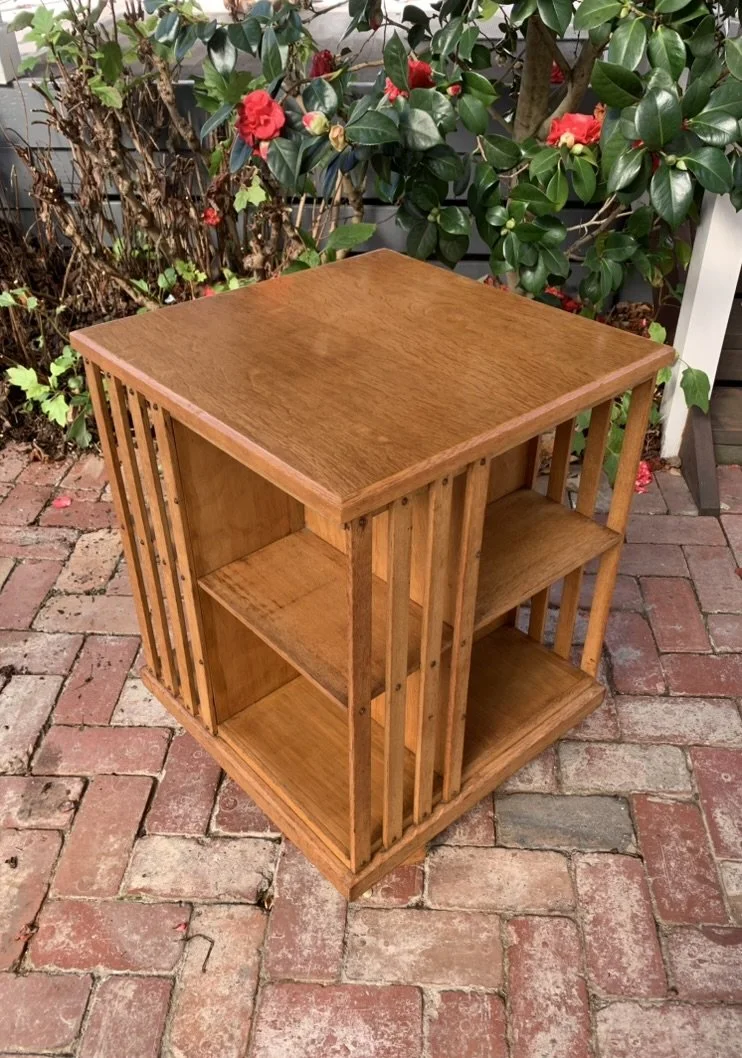 English oak revolving bookcase, empty shelves, showing slatted sides and castor base, circa 1910