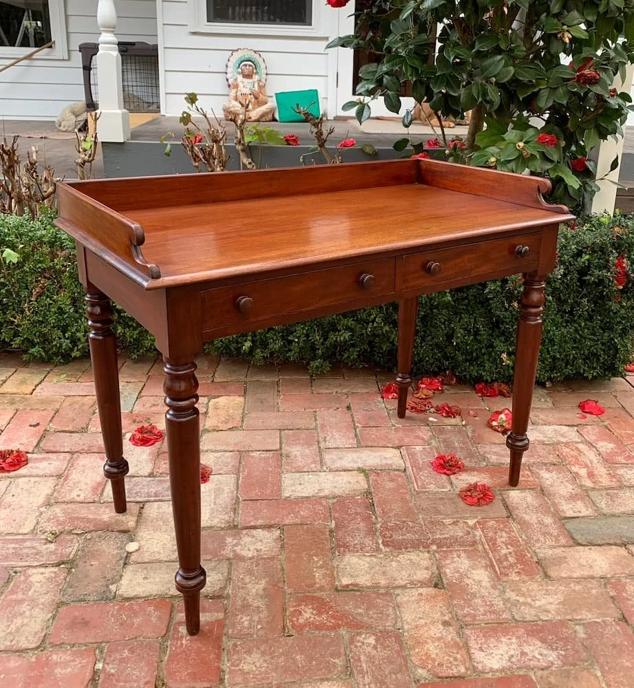 Victorian mahogany desk side table C.1870 with three-quarter gallery back, scroll ends and turned legs