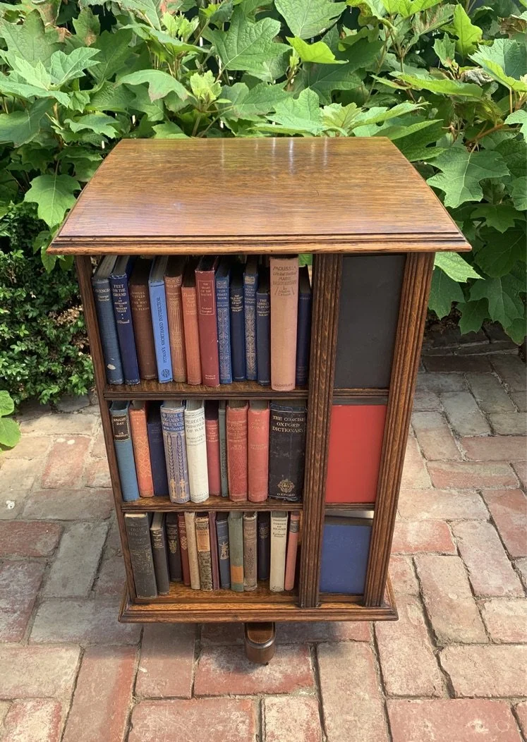 Edwardian oak revolving bookcase c.1910 front view, three tiers, turned central column on moulded plinth base
