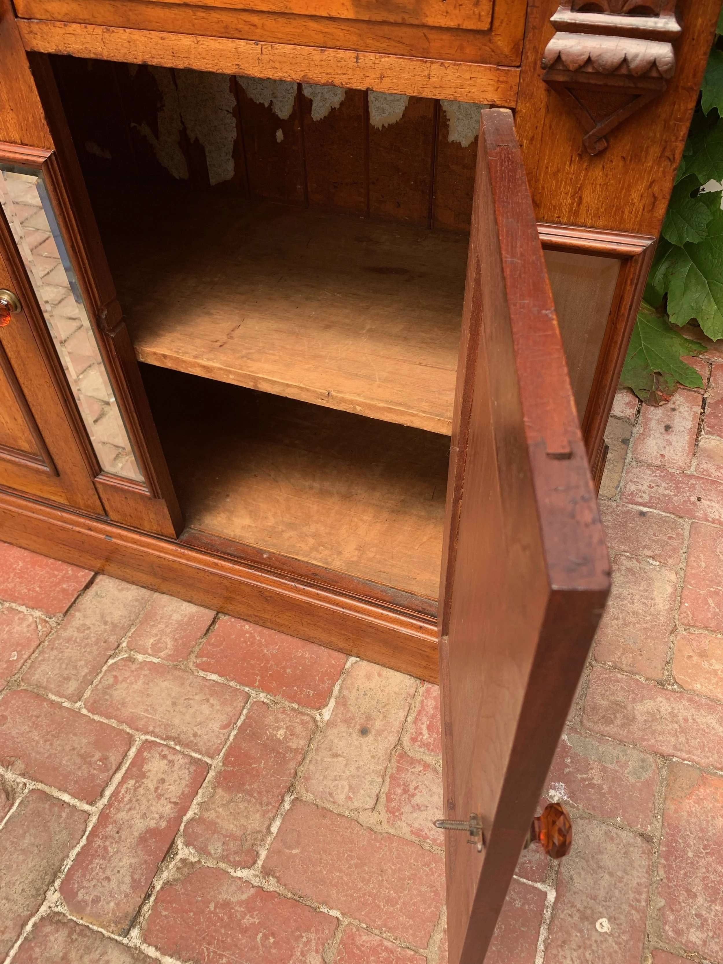 Inside lower cabinet of Antique Australian cedar Victorian bookcase circa 1890 with glazed upper cabinet, beveled mirror panels, carved corbels and original amber glass knobs