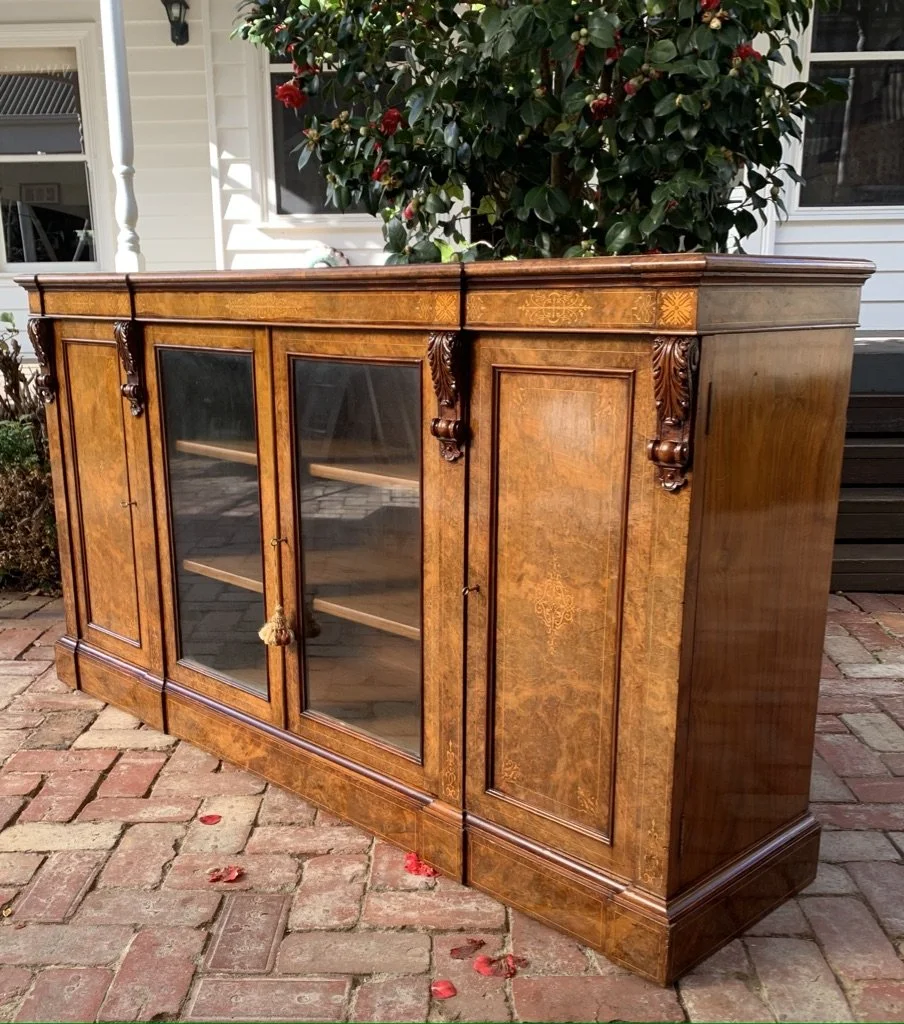 Victorian burr walnut breakfront dwarf bookcase, c.1860-80, glazed centre doors and carved acanthus corbels, angled view