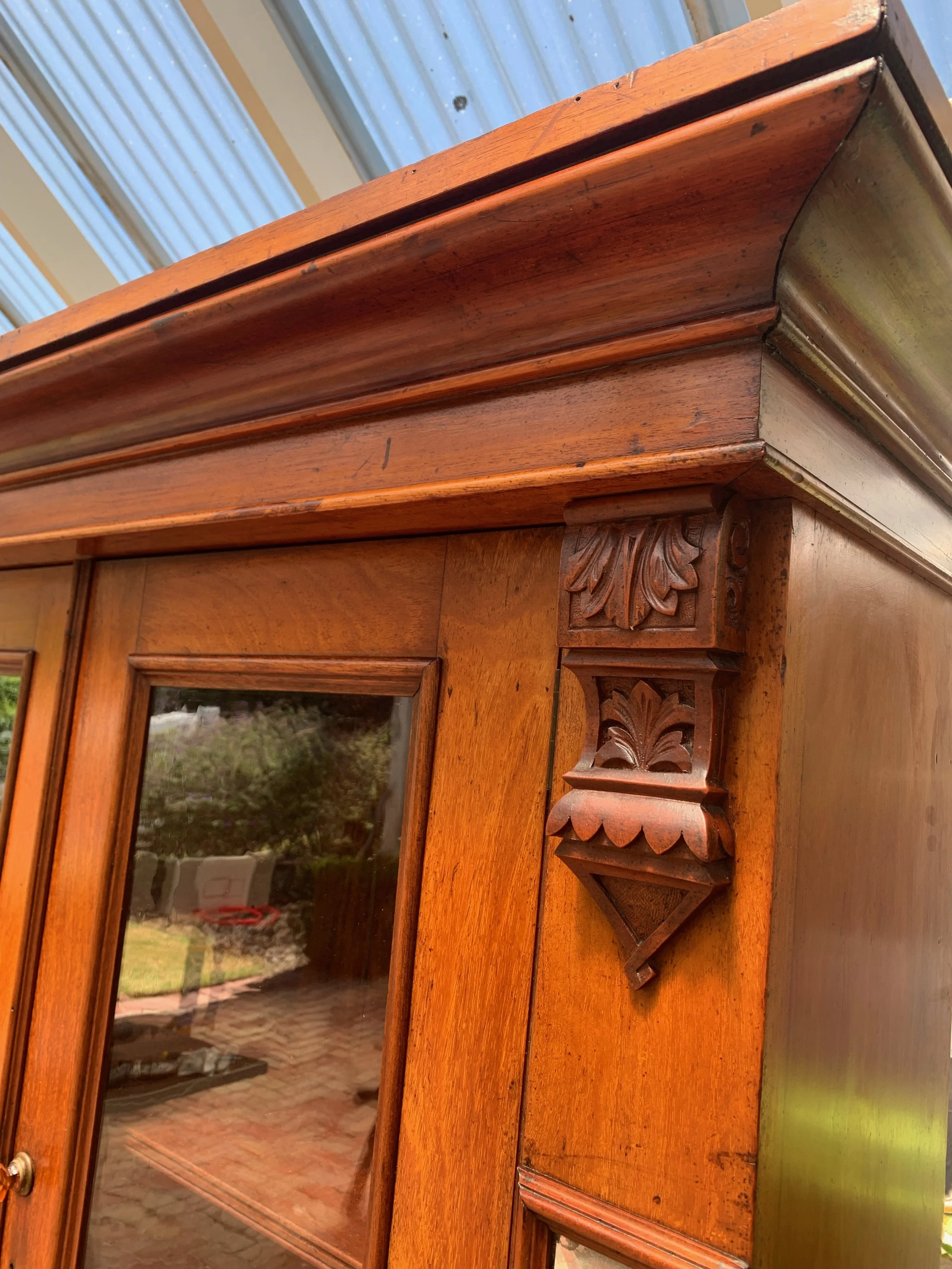 detail of carved corbels and stepped cornice on upper glazed section on Antique Australian cedar bookcase circa 1890  