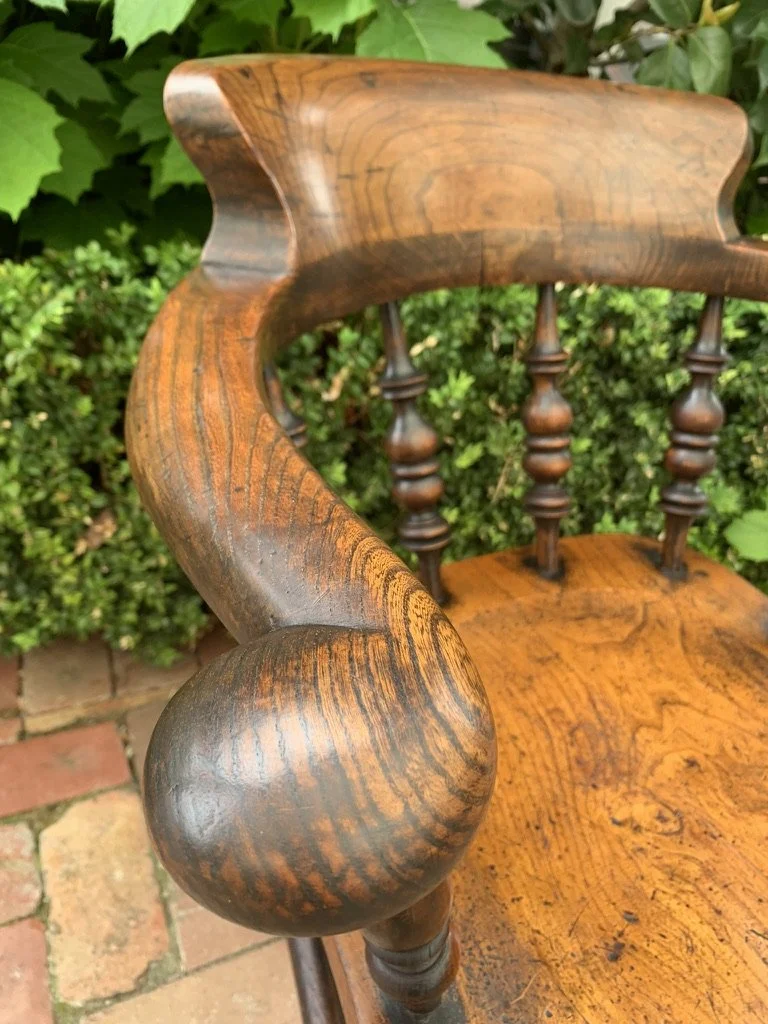 Close-up of English elm smoker's bow chair horseshoe arm, showing fine natural patina and elm grain figuring