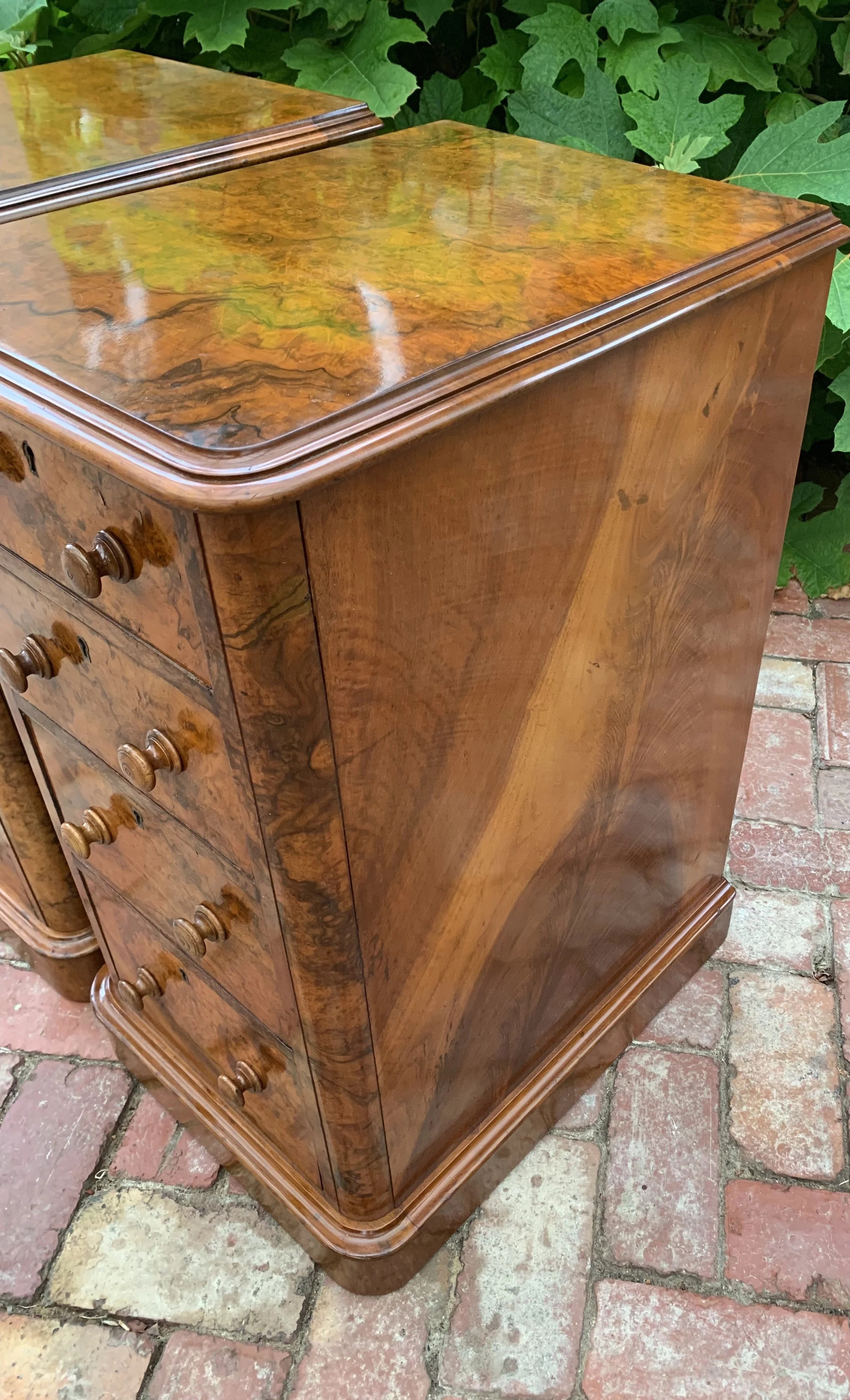 side view of pair of antique burr walnut bedside chests with graduating drawers and turned knobs circa 1870 