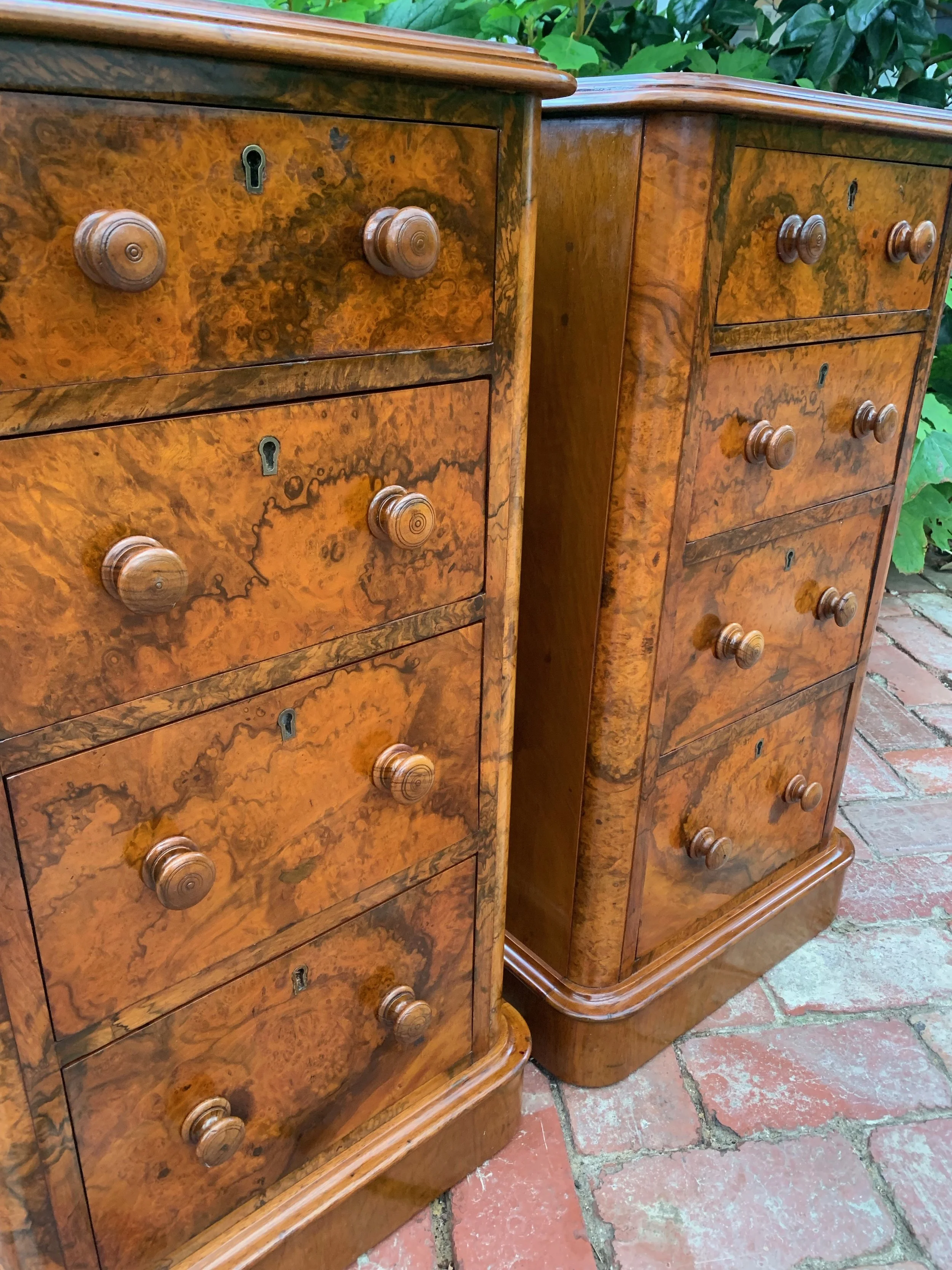 close view of drawer fronts of pair of antique burr walnut bedside chests with graduating drawers and turned knobs circa 1870 