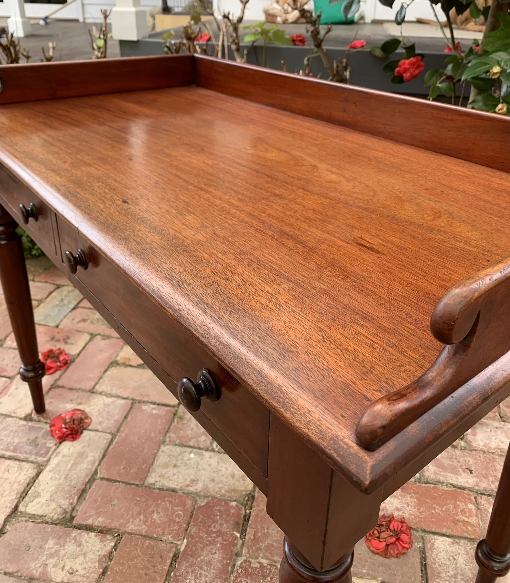 Close-up mahogany grain and turned wood knob, Victorian side table gallery back detail
