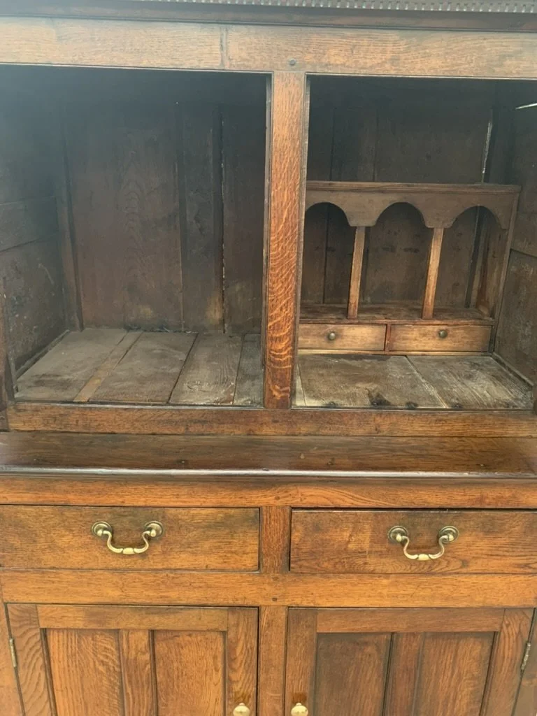 Interior of Welsh oak cwpwrdd deuddarn showing open shelving and small spice rack with two drawers, antique cupboard