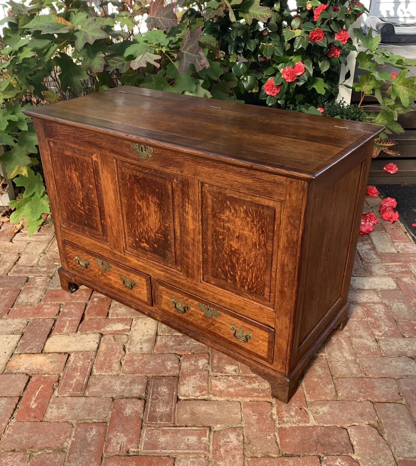Georgian oak mule chest side view, mahogany crossbanding, bracket feet, original brass swan-neck handles