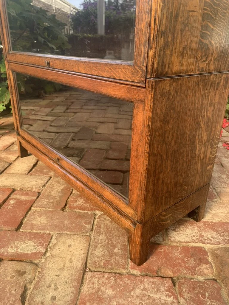 Detail of lower section and tapered foot on antique English oak barrister bookcase with glass-front door