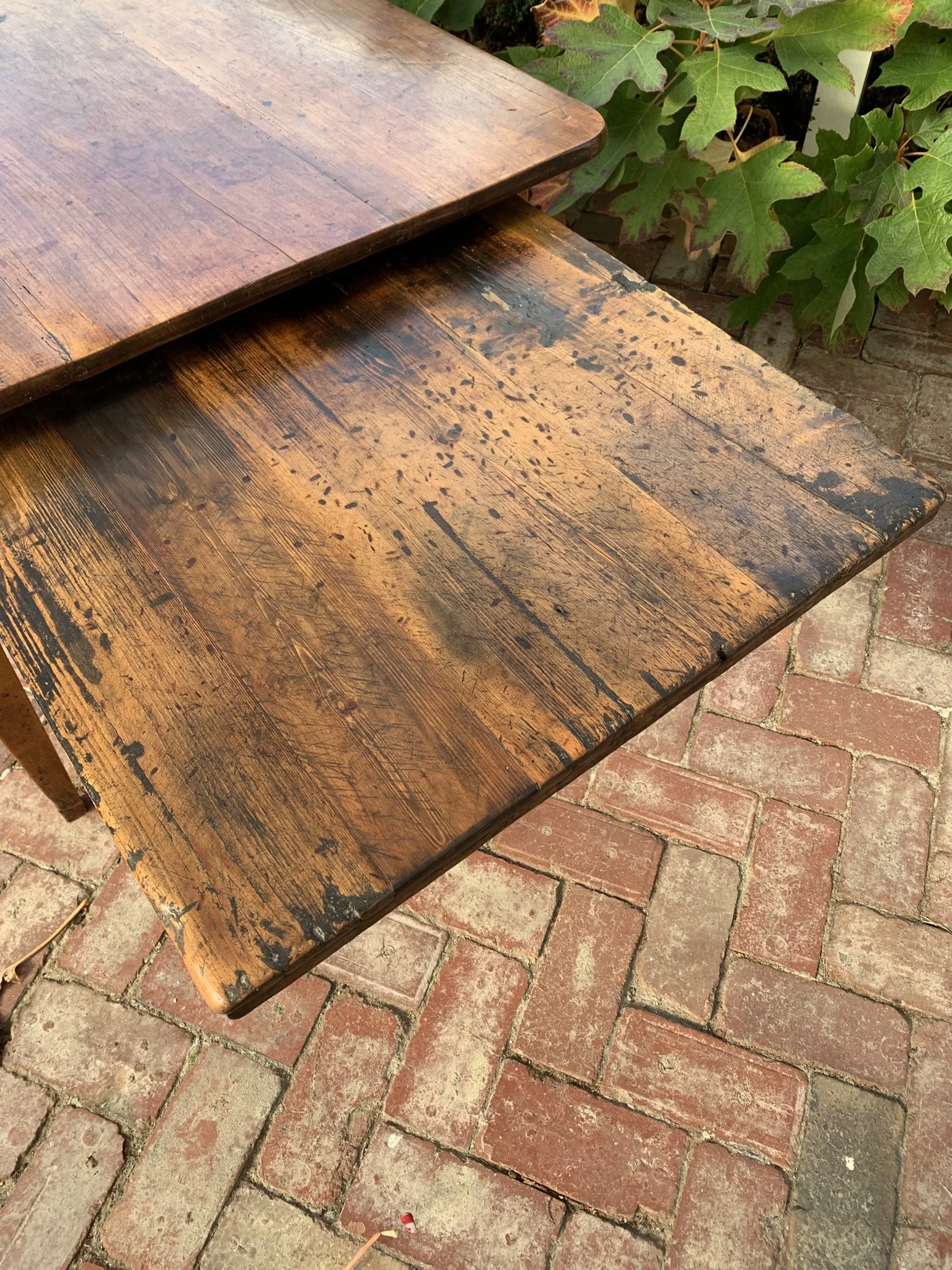 Close up of heavily worn pull-out bread board on antique French dining table, original patina