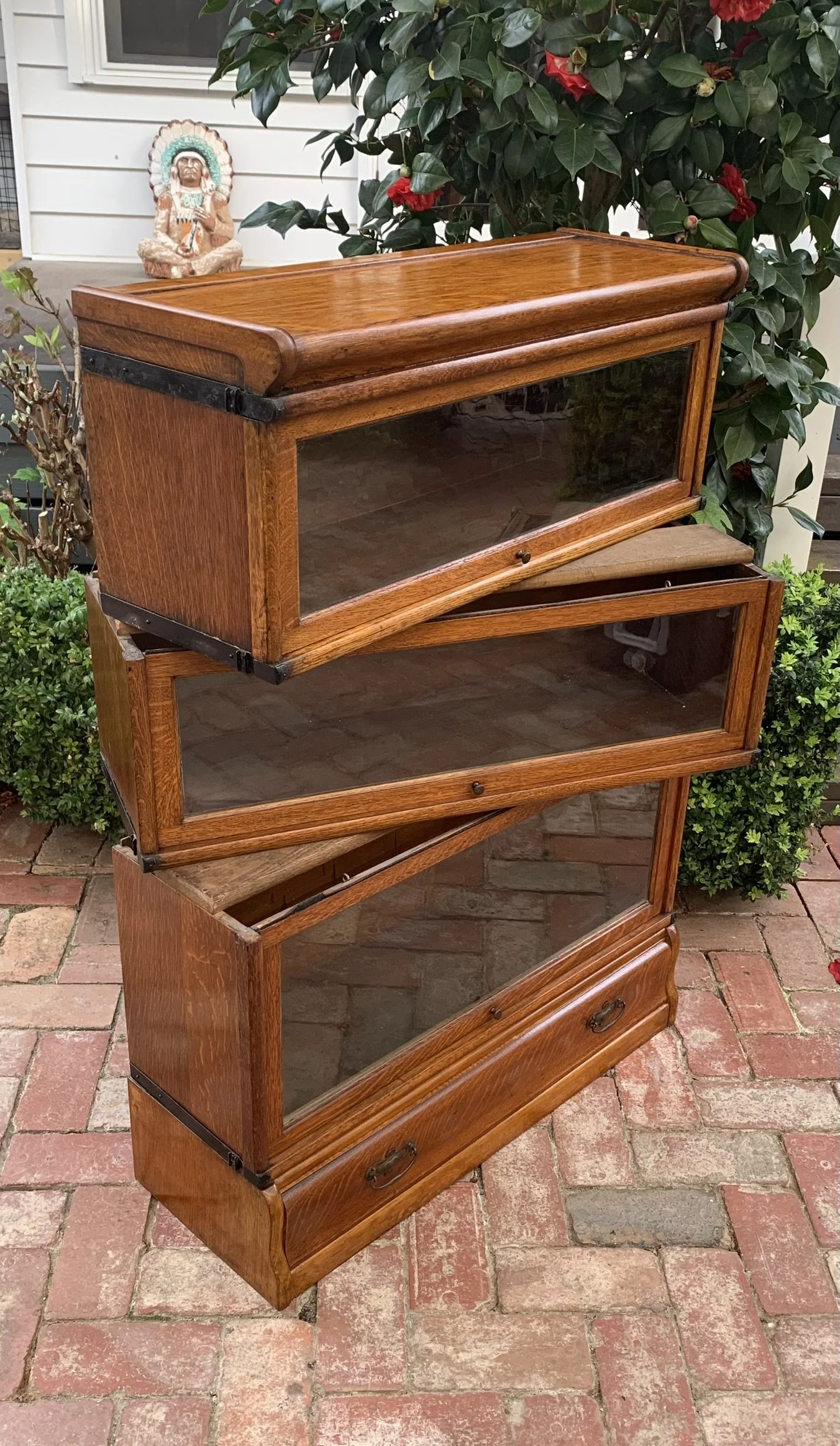 English oak Globe Wernicke barrister bookcase, C.1910, three stacking sections shown offset to display the sectional construction, lower drawer with brass handles