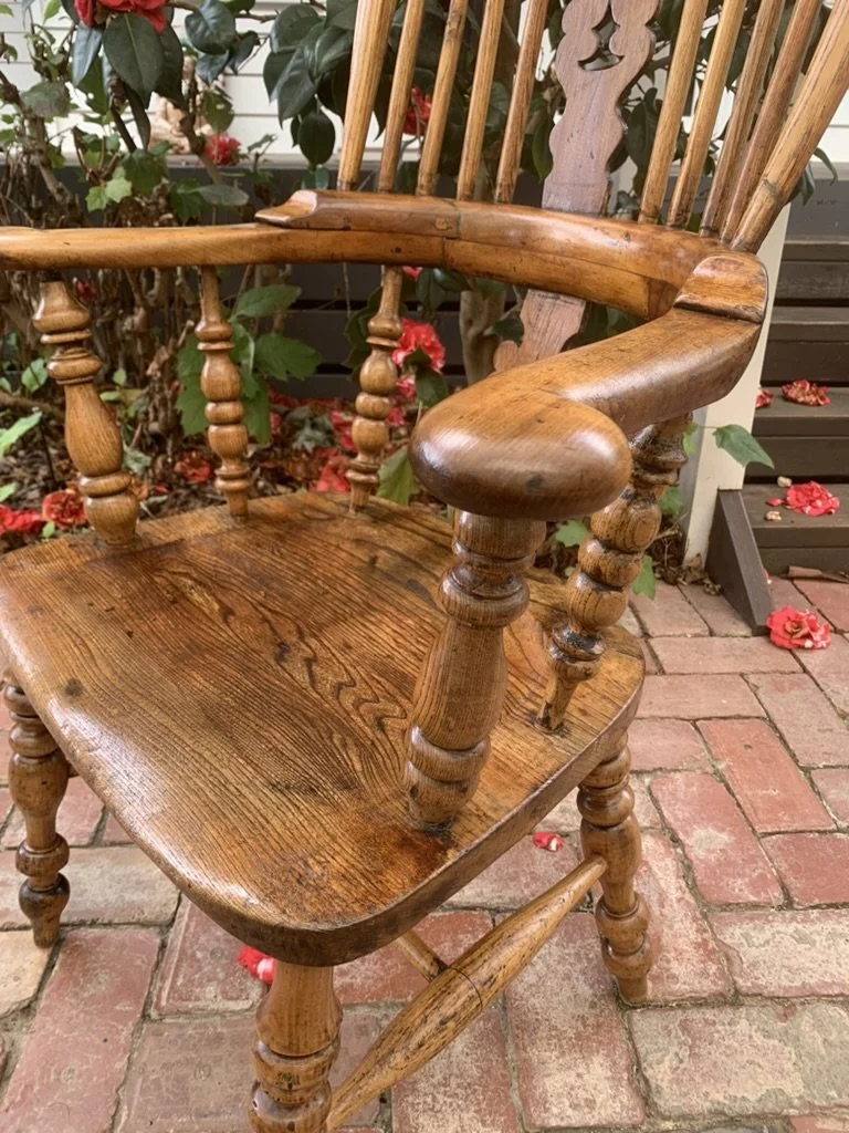 Close-up of elm saddle seat and turned oak arm supports on antique Windsor armchair, C.1880