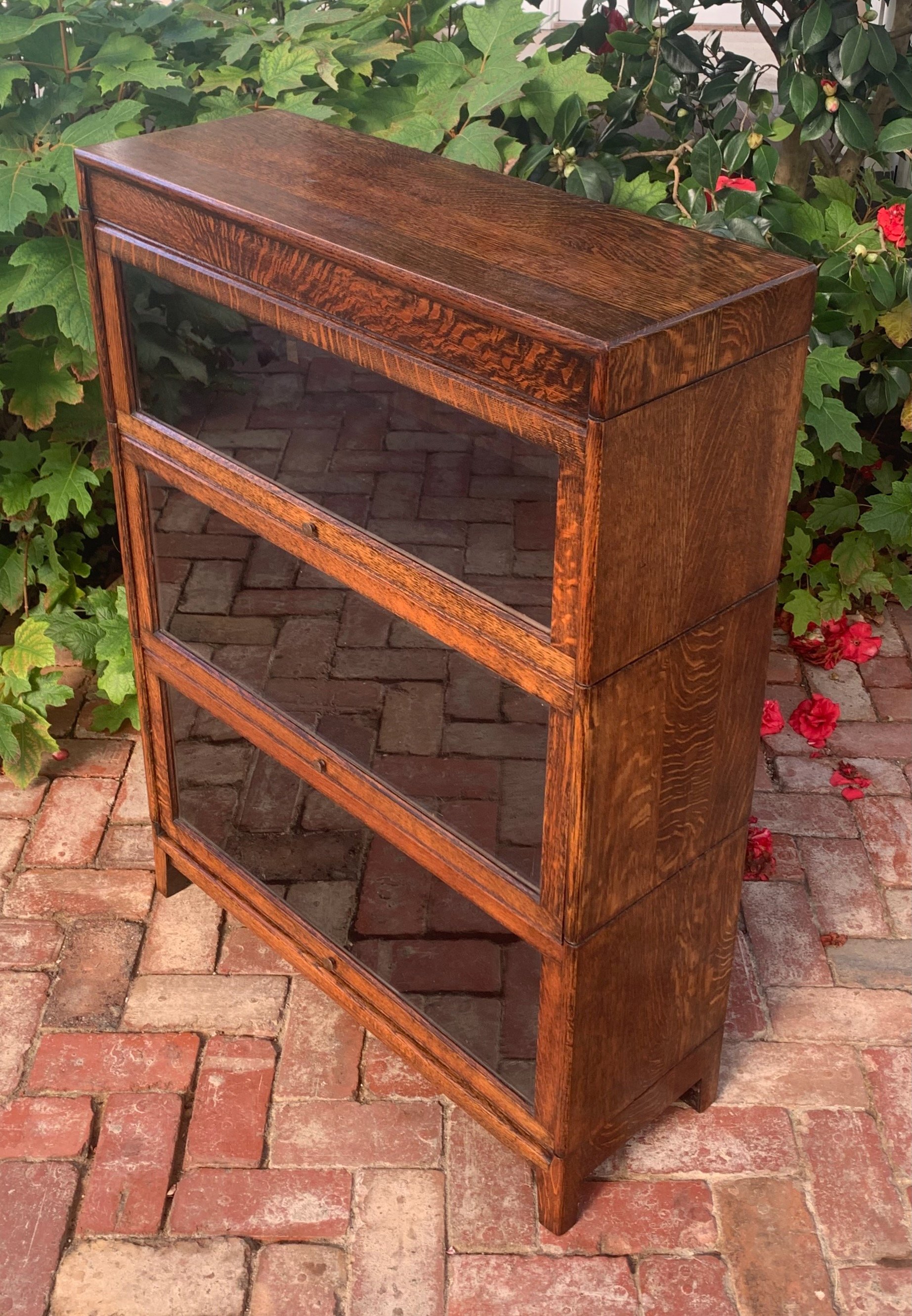 Angled view of English oak barrister bookcase c.1920-1930 showing tiered glass-front stacking sections