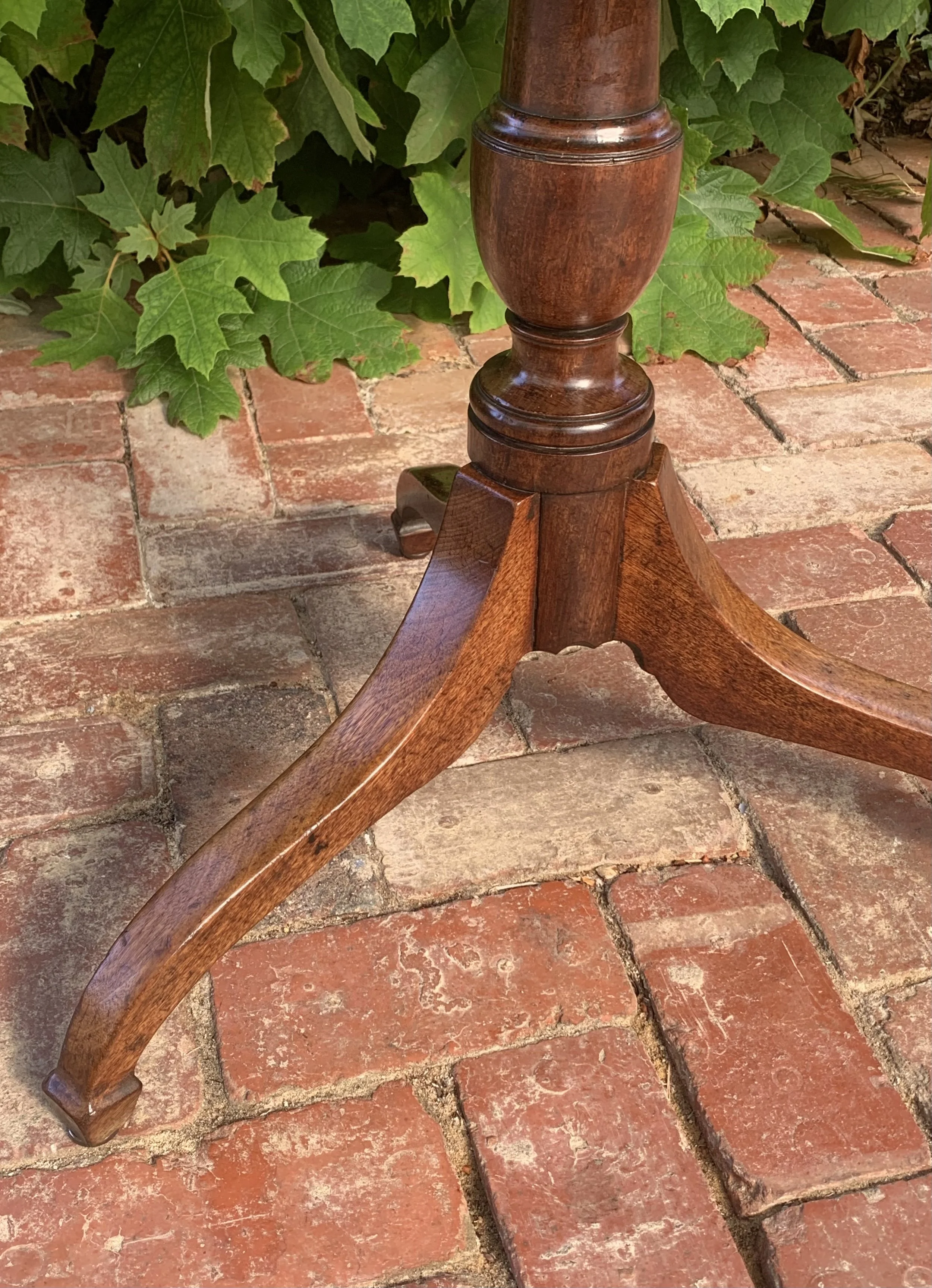 Close up view of tripod spider legs and spade feet of georgian mahogany tilt-top wine table