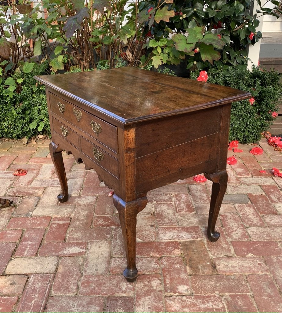 English oak lowboy c.1730–1750, cabriole legs, shaped apron, brass escutcheons — three-quarter rear view