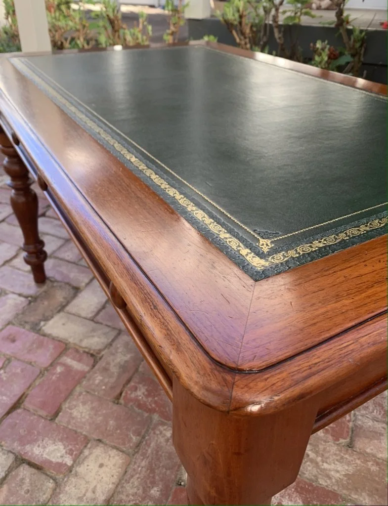 Close-up of gilt-tooled green leather writing surface on antique cedar desk, gold blind-tooled scrolling border detail, 19th century