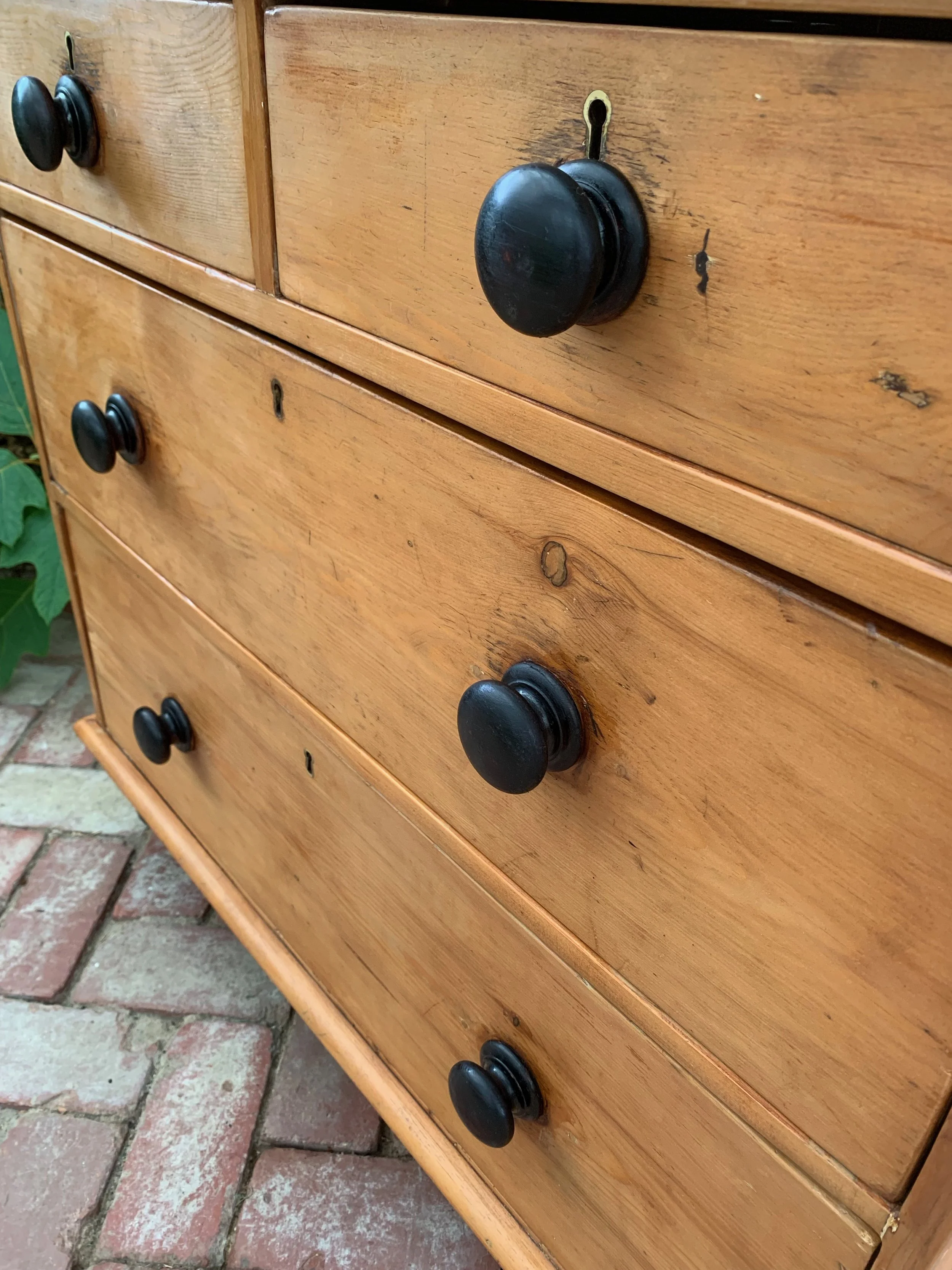 Close up angled view of late 19th century stripped pine chest of drawers