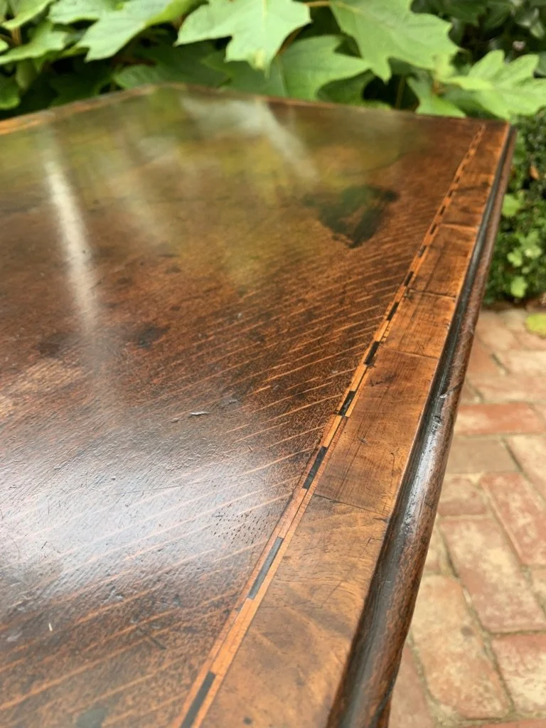 close up of inlaid and cross banded top of georgian oak side table