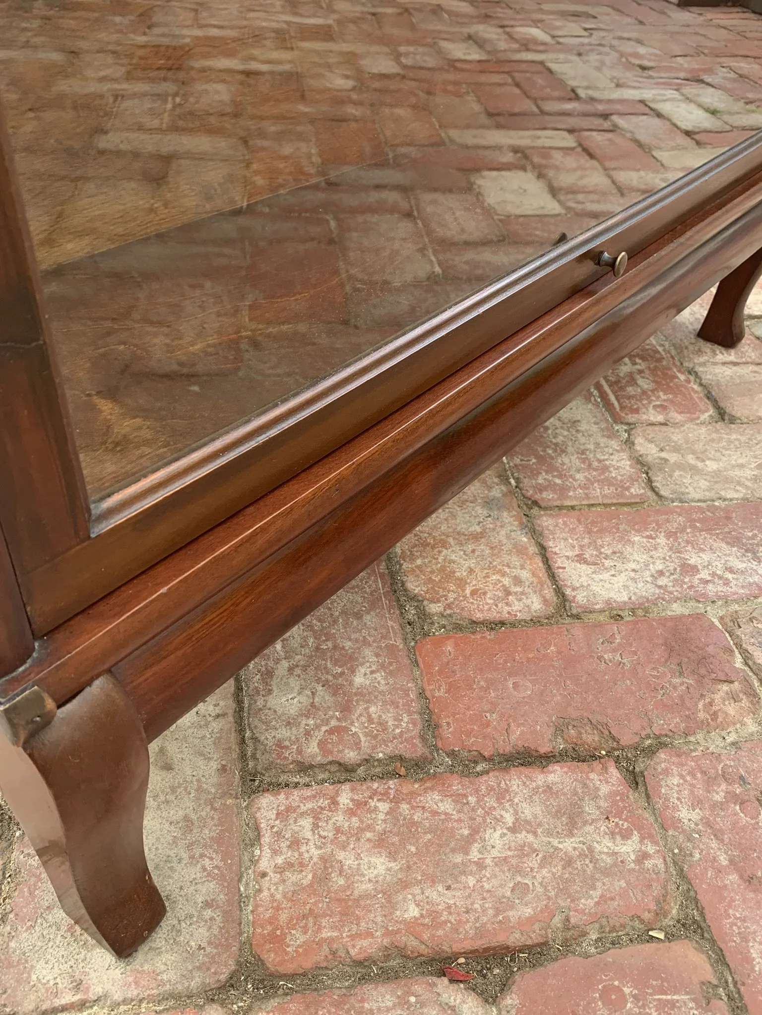 Shaped legs and base detail on antique mahogany bookcase