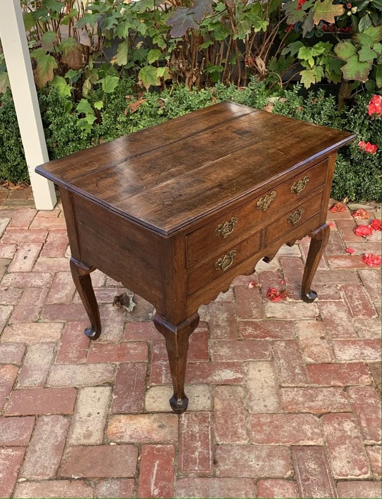 Antique Georgian oak lowboy c.1740, three-plank top, shaped apron, cabriole legs with pad feet — three-quarter view