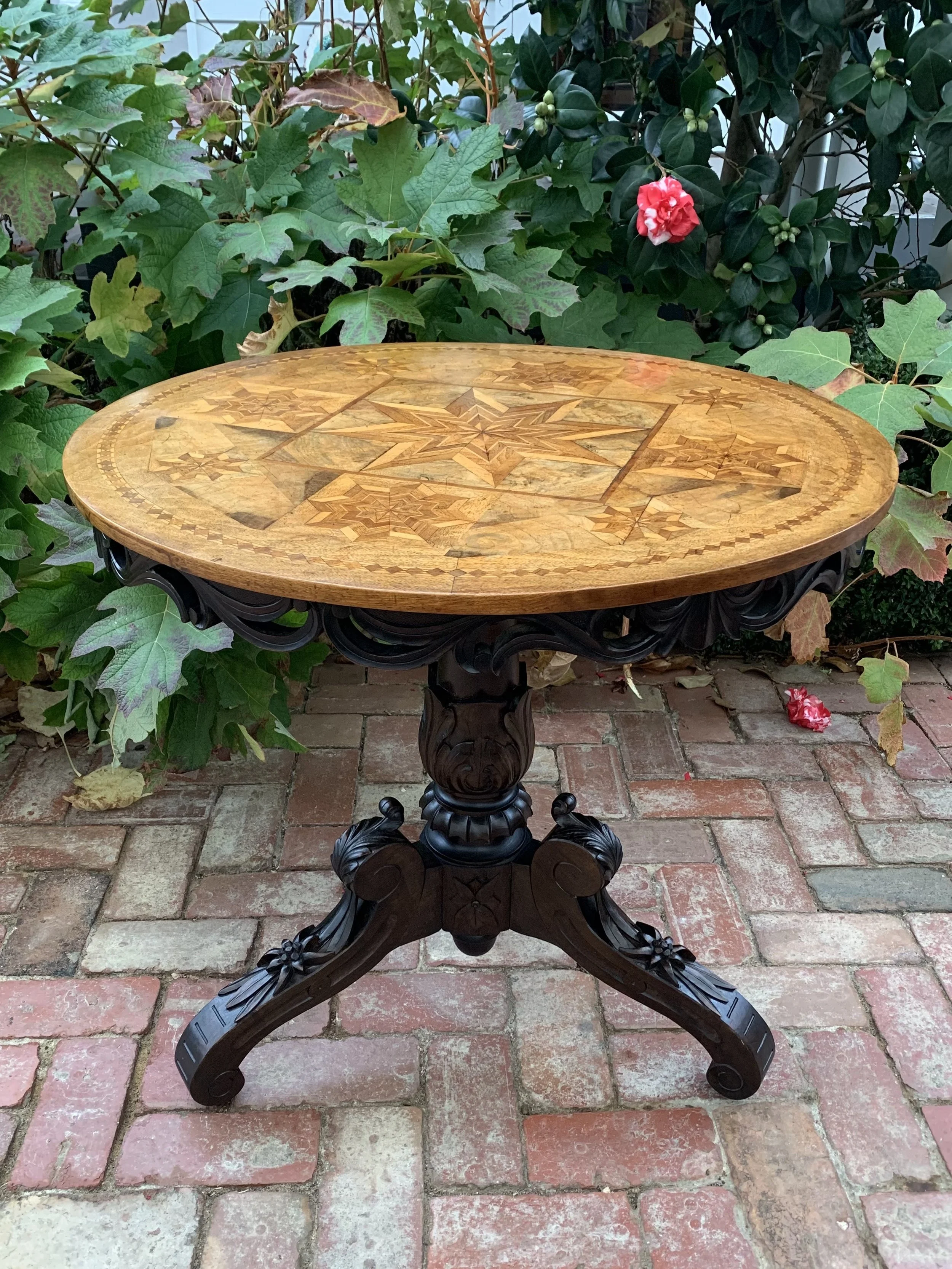 Antique italian parquetry top tilt-top table with heavily carved walnut tripod base