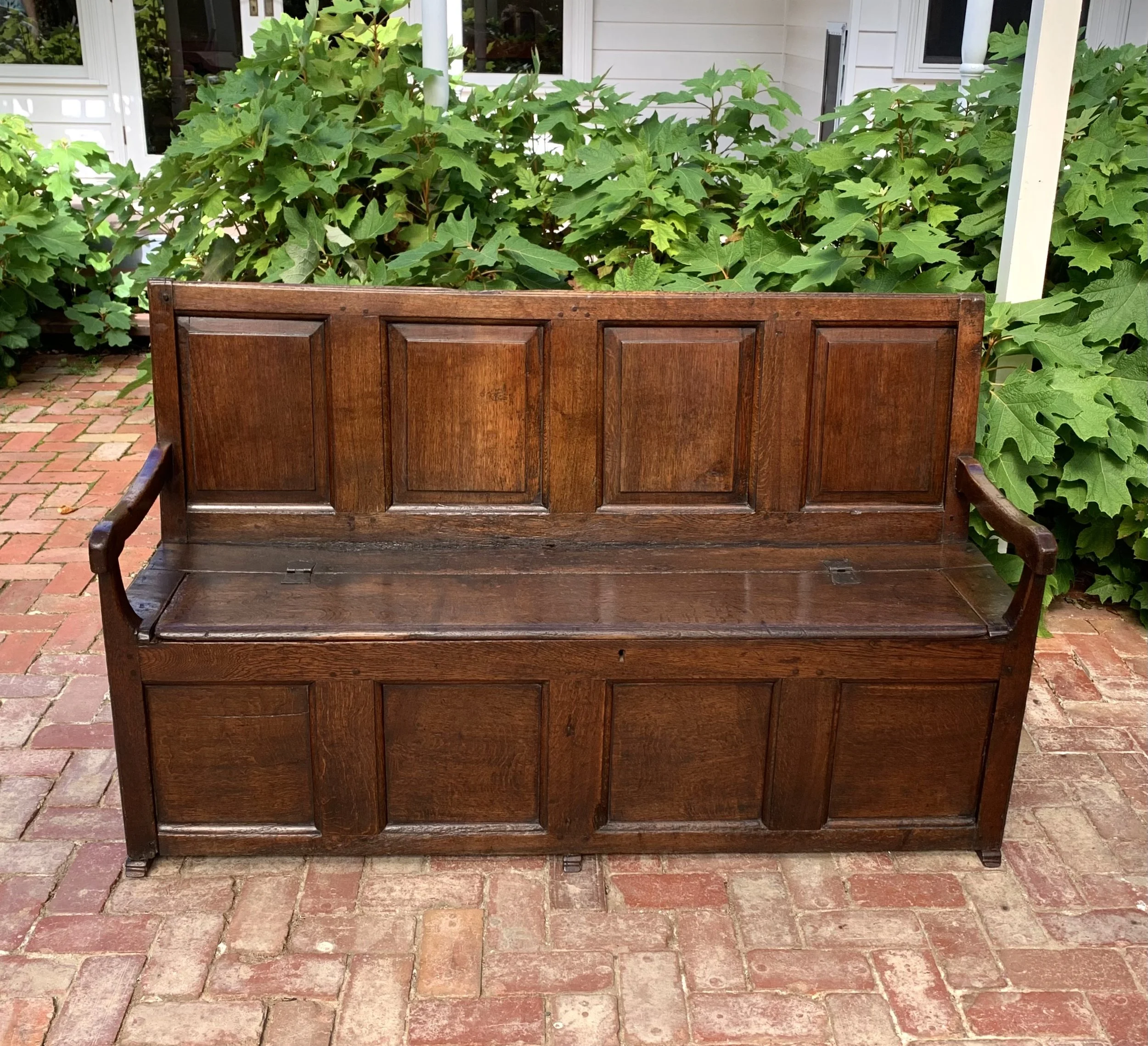 Antique provincial oak box settle with panelled back and lift-up seat on sledge feet c.1720