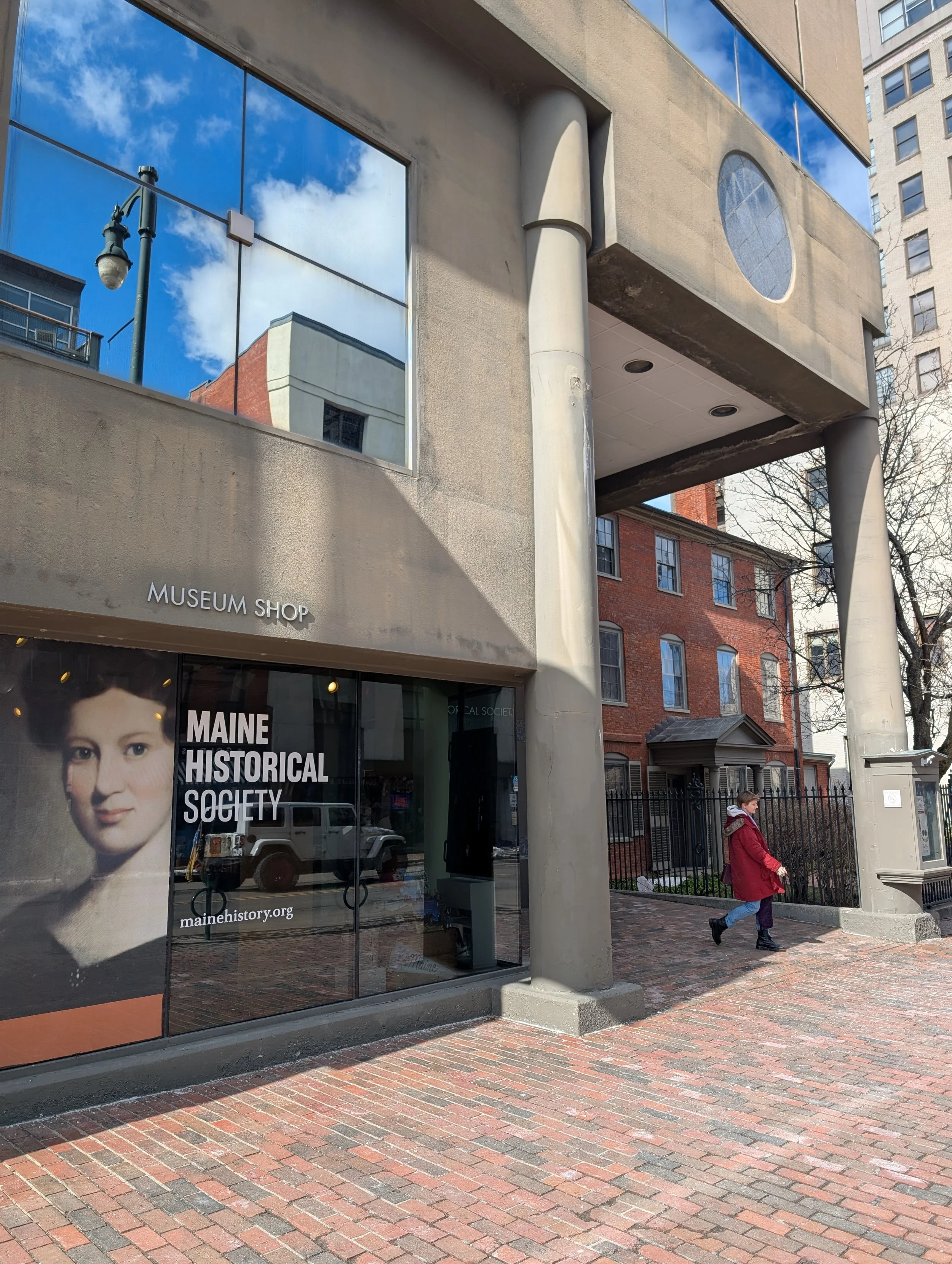 Early 90s architecture with tinted glass bearing the organization's logo and a portrait painting of a young white woman